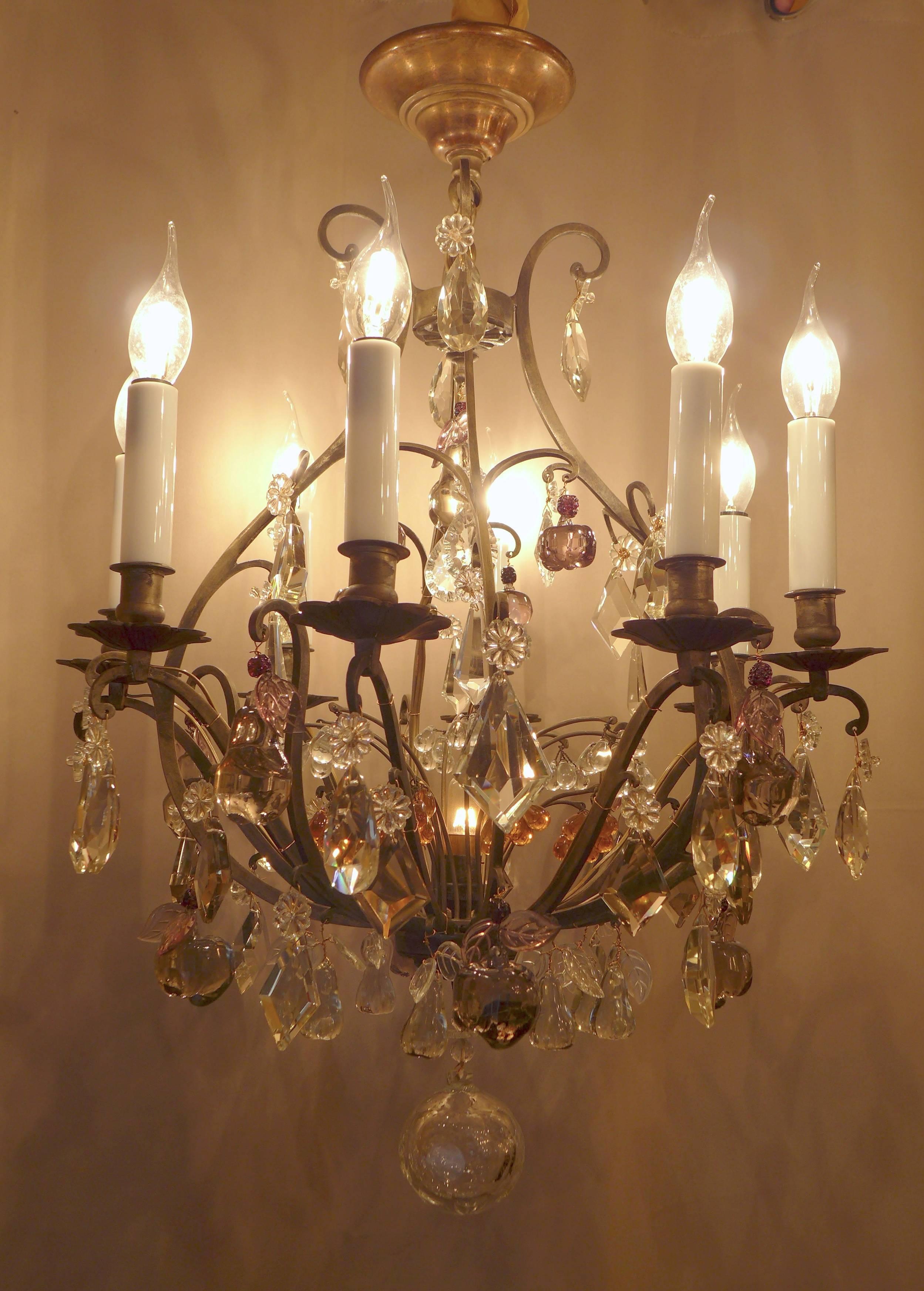 Lovely small patinated bronze and crystal form cage chandelier in the classical Louis XV style. The chandelier is composed of height arm lights. Interesting and gorgeous top quality hand-cut crystal pieces, small pears, pears, apples, grapes,