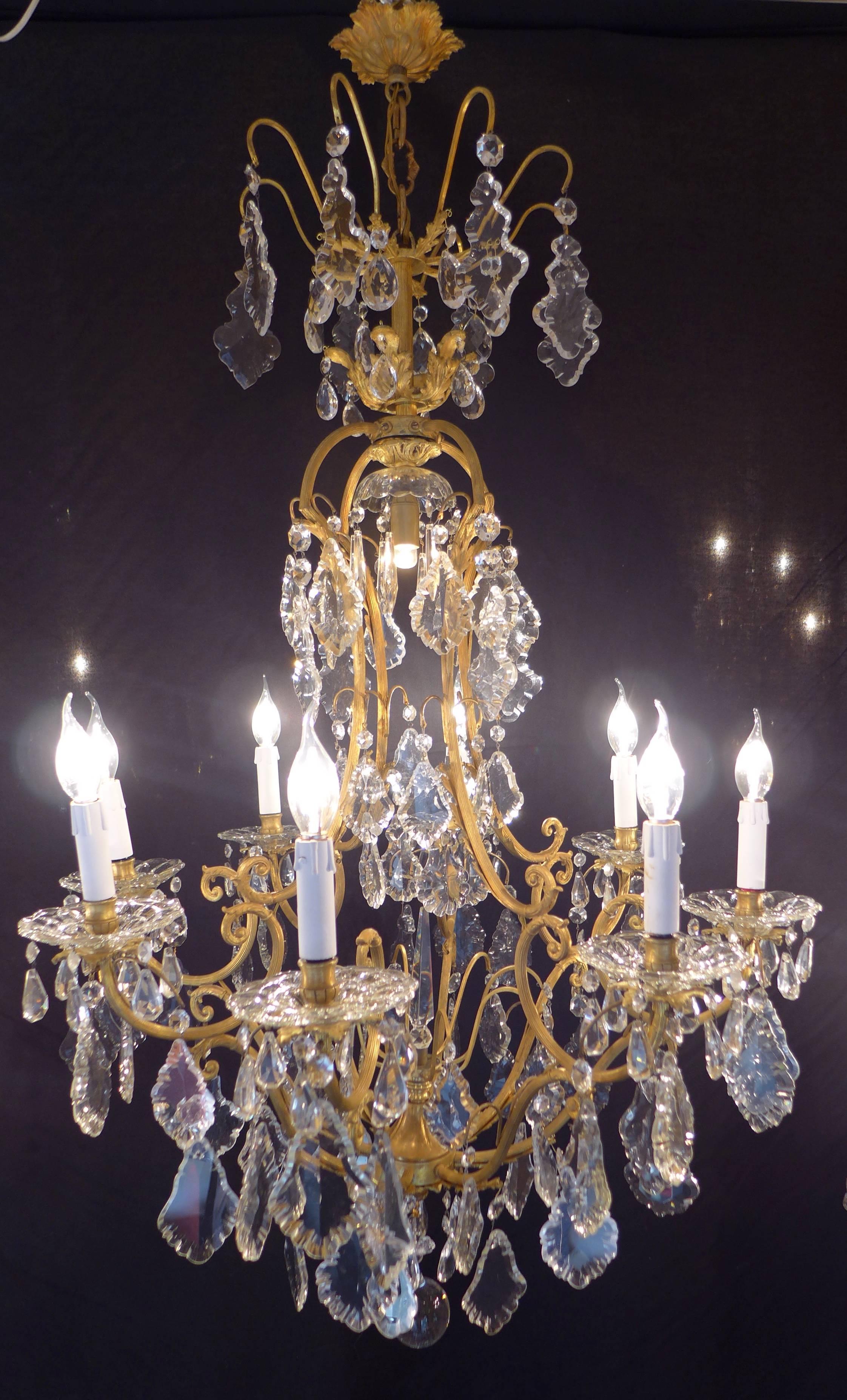 Gorgeous ormolu and crystal, form cage chandelier in the classical Louis XV style. Our chandelier is composed of height perimeter arm lights and one inside light. Fine quality hand-cut crystal pieces (white), plaques, in the center one crystal knife