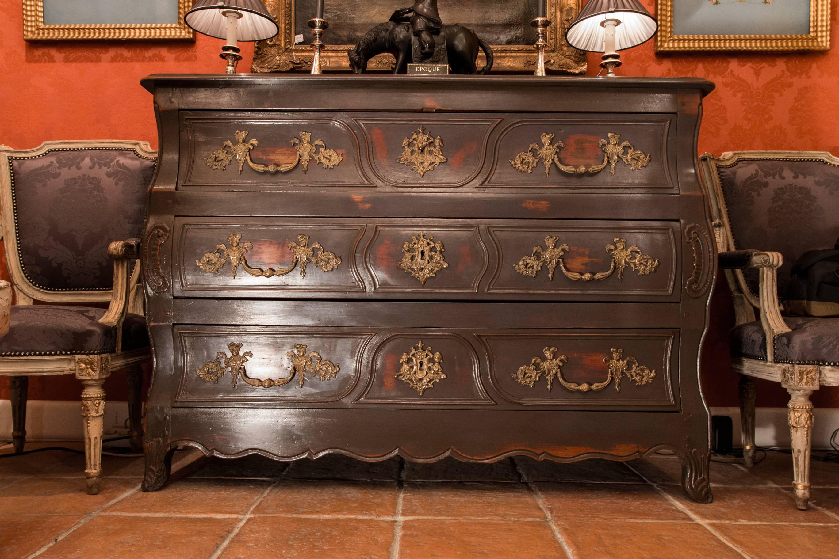 A decorative large French castle commode, in hand-carved wood painted in grey, opening by three large drawers with decorative gilt-bronze handles « Aux Valets ». Our chest rests on small serpentine foots. 

Provincial French work mid-18th century