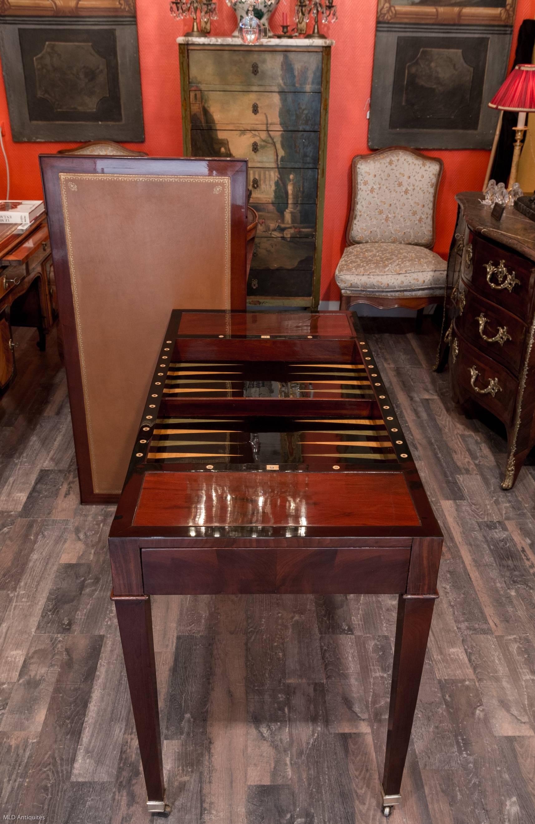 French Directoire period Tric -Trac or « jeu de Jacquet » game table in mahogany and mahogany veneer. Very pratical removale and reversible top with handsome decorated leather. One side serves as a small desk and the reverse side of the tabletop