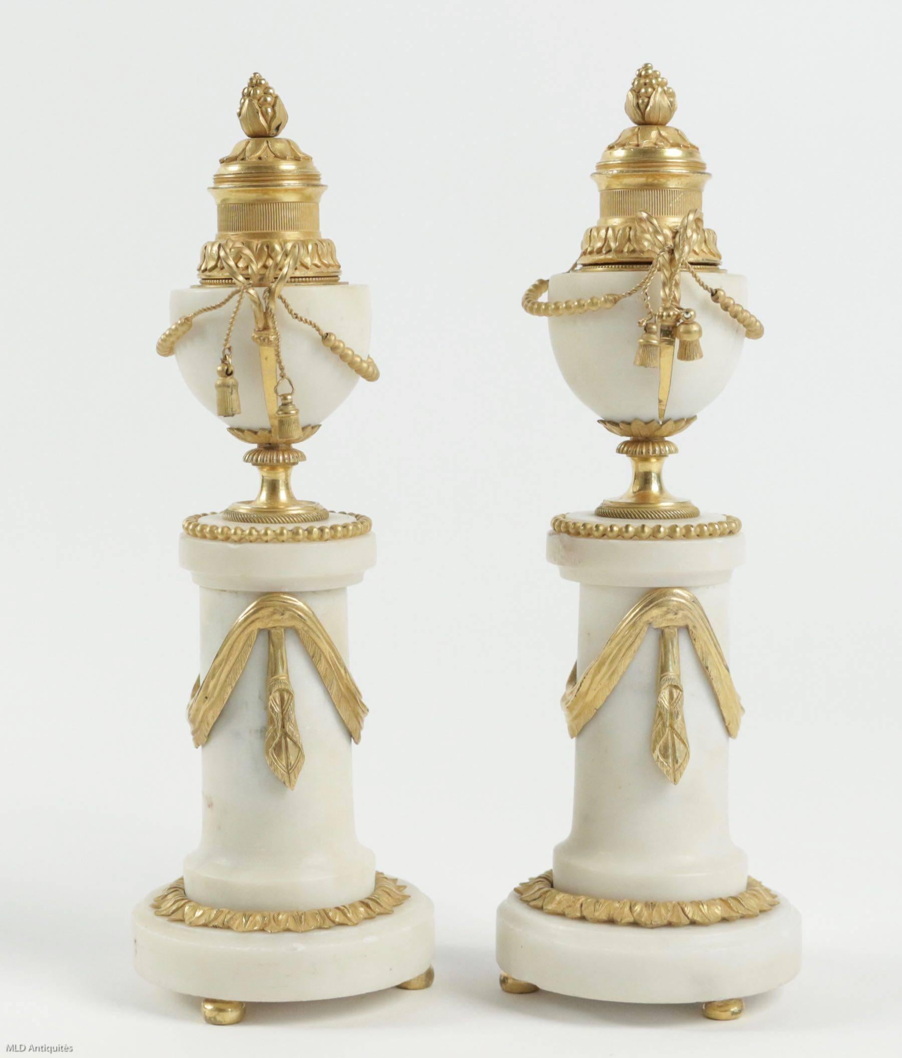 Lovely pair of cassolettes, the moving top is forming candlesticks.
Carrara marble and bronze finely carved in original beautiful gilding.
Gorgeous French Directoire period, manufactured late 18th century, circa 1795.

Measures: Candelabra
