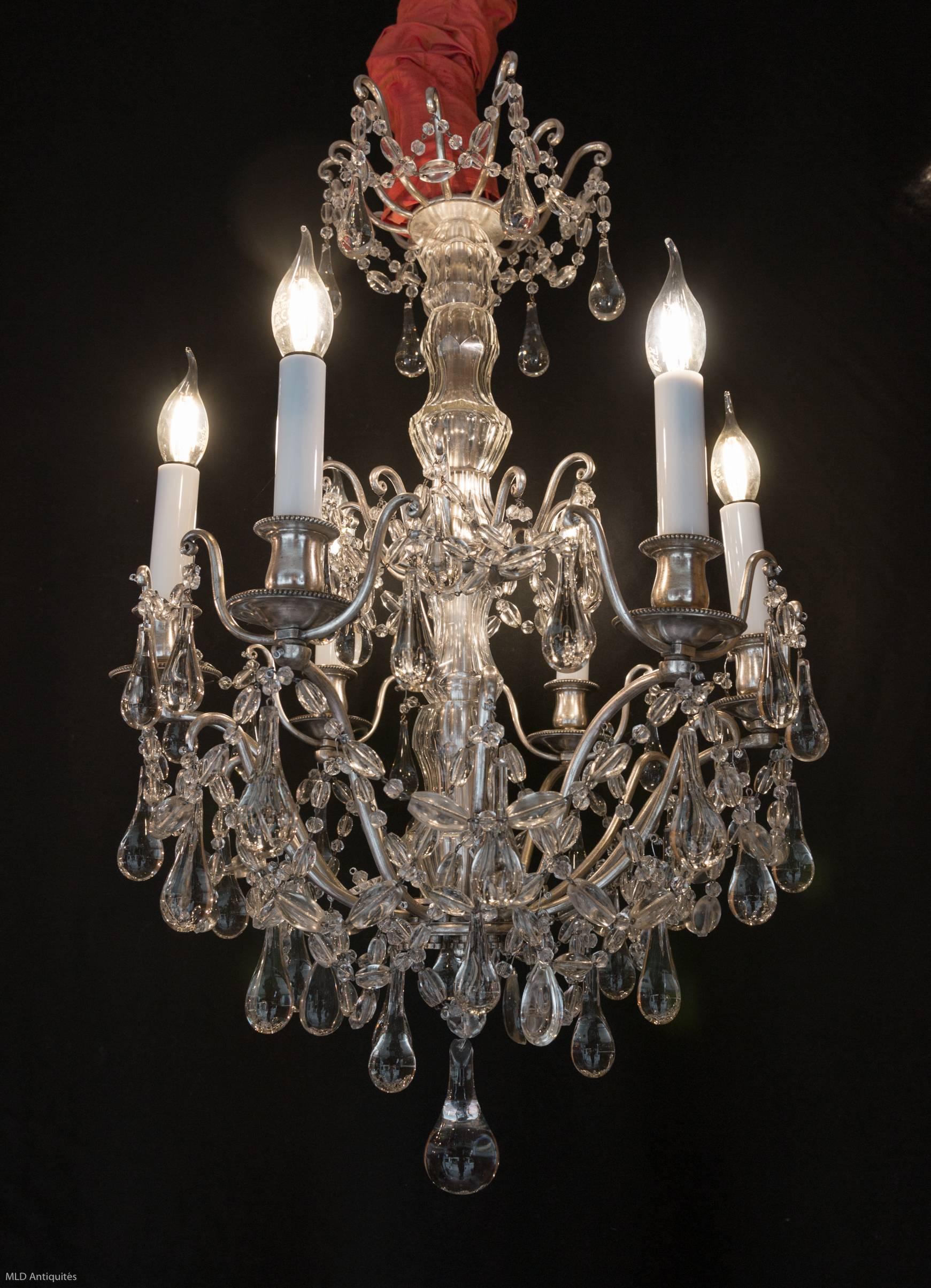 Lovely an decorative original old silver plate and hand cut crystal small chandelier in a classical Louis XVI style.
Interesting fine quality crystal, almond and water drops. The chandelier is terminated by a lovely crystal water dorps ball.
Our