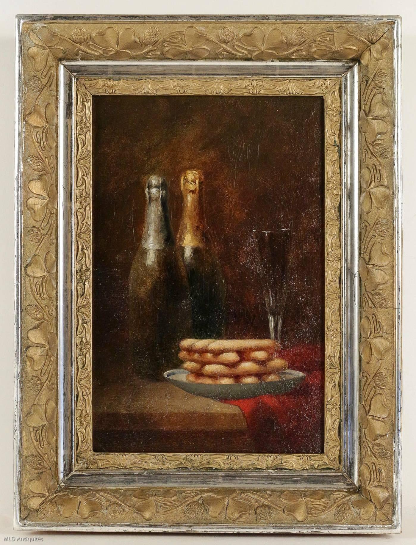 We are pleased to present you an interesting oil on canvas, depicting a still of life, with a city of Reim's pink cakes in an earthenware cup, two bottles of champagne and a champagne flute, on a red fabric ledge.

Beautiful hand-carved gilt and