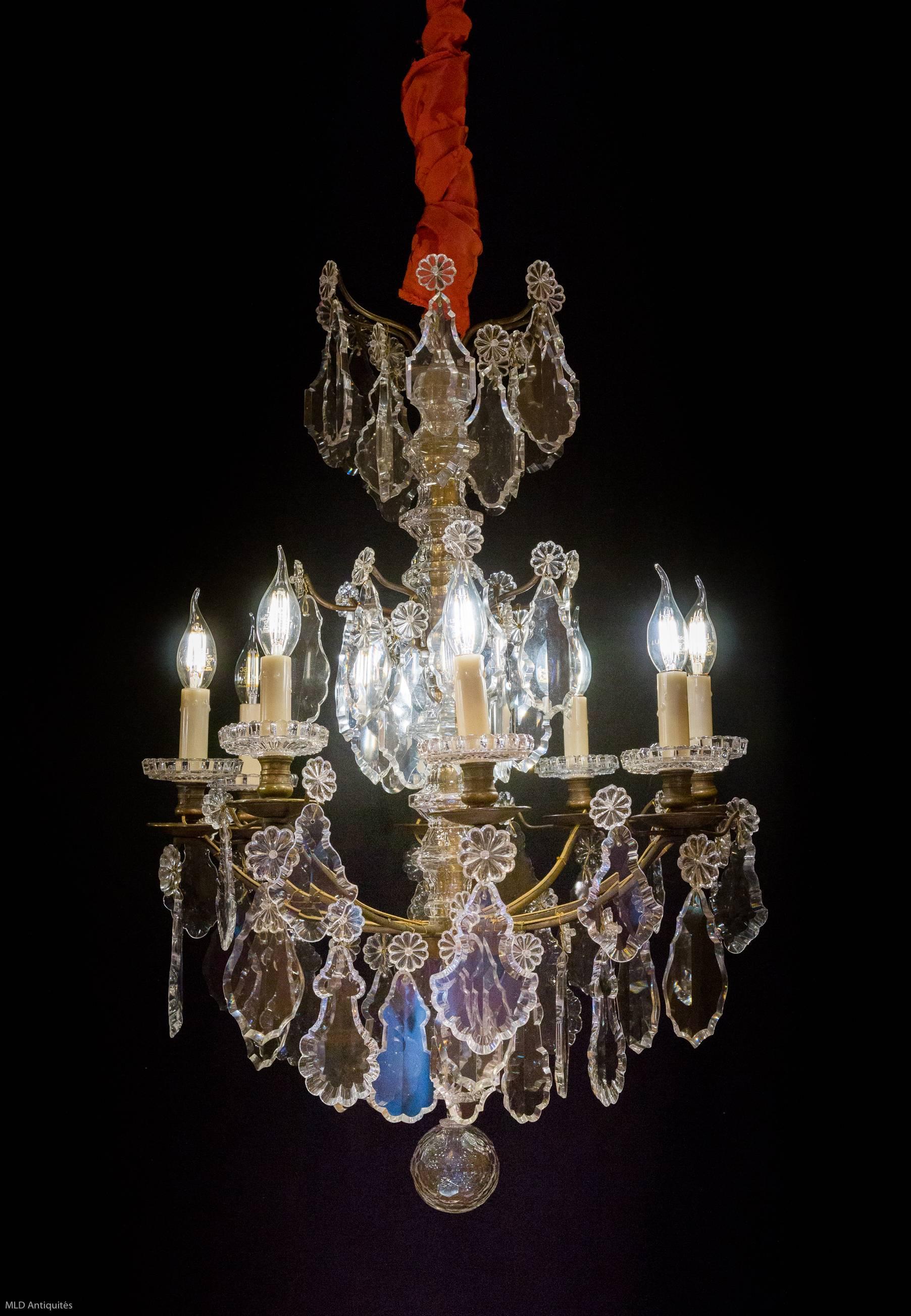 We are pleased to present you a lovely ormolu patinated and hand-cut crystal, form "tige" chandelier in the classic Louis XIV style. Our chandelier is composed of height arm lights.

Baccarat fine quality hand-cut crystal plaquettes and