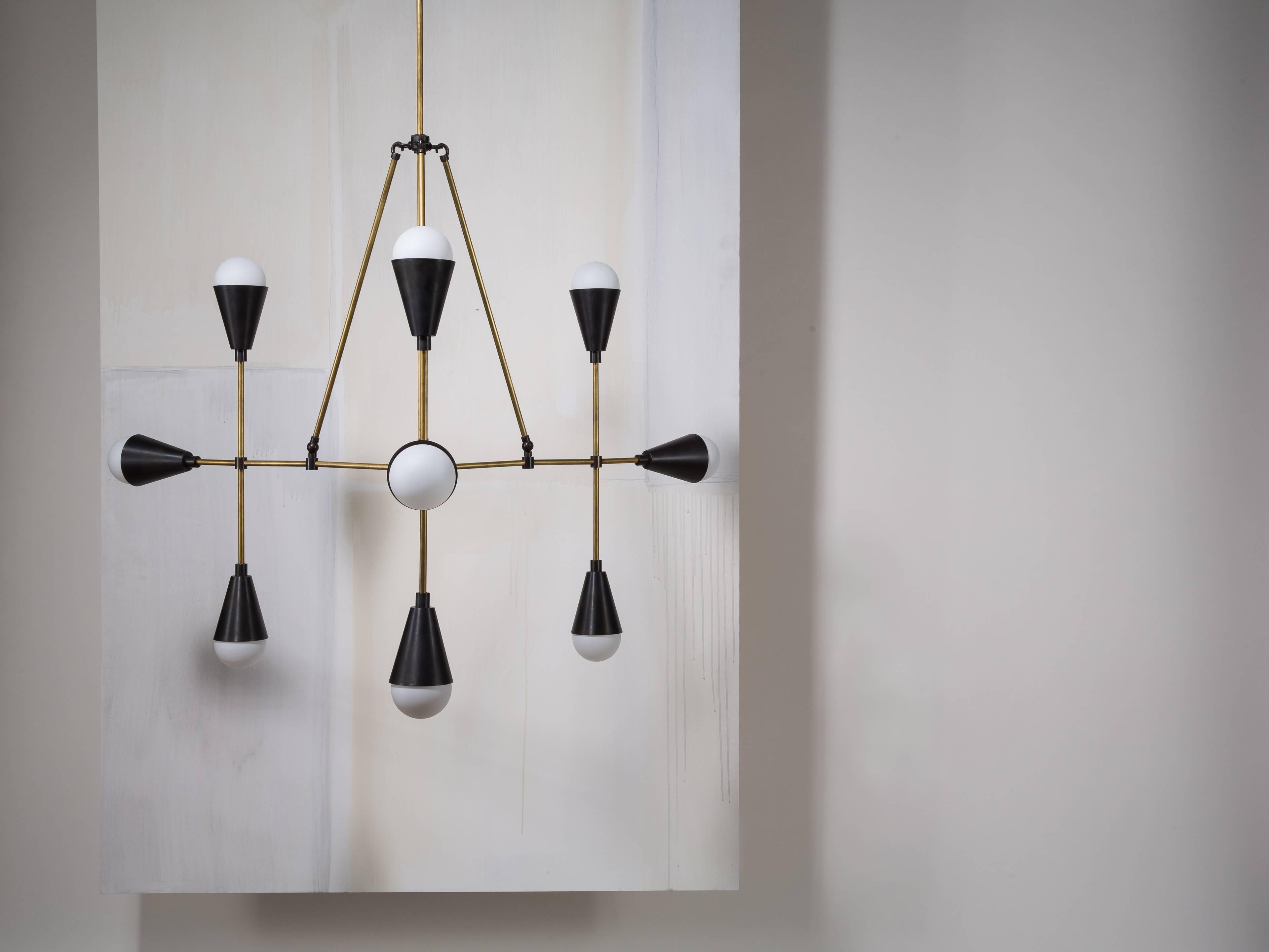 Drawing on trigonometric principles, these fixtures are a study in repeating triangular and conical shapes. Solid brass, or with hand cast porcelain cones that emit a delicate glow. 

Made to order and finished and assembled by hand in New York