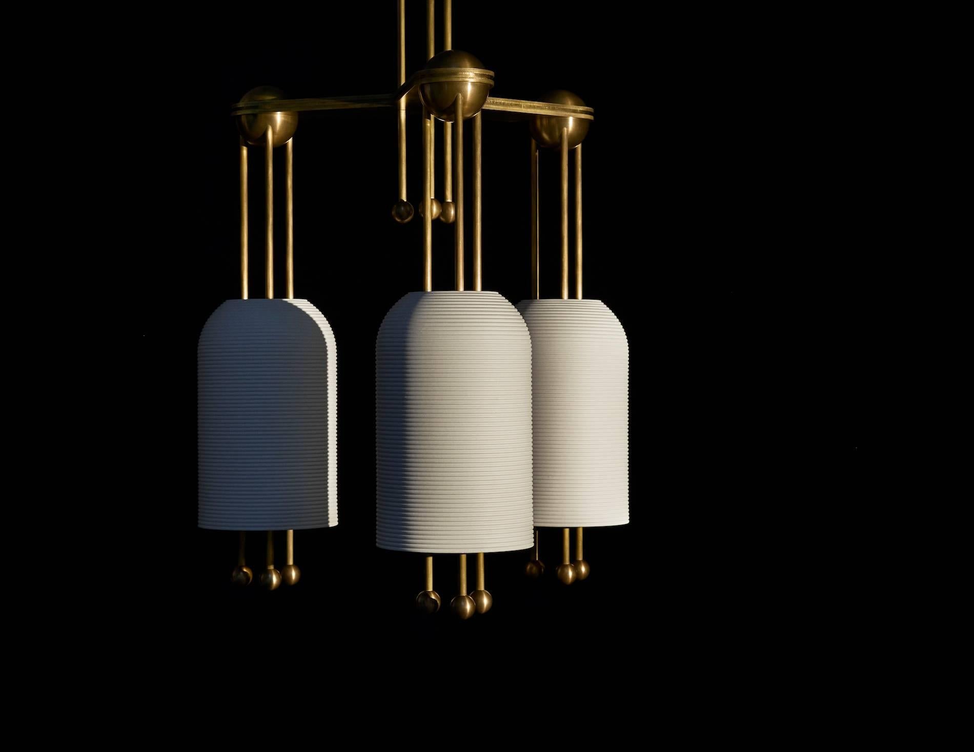 The slip-cast porcelain forms of the Lantern series float along a rigid brass structure. Their glow is punctuated by finely incised fluting, connecting to the most essential element of historical lanterns - light passing through a delicate