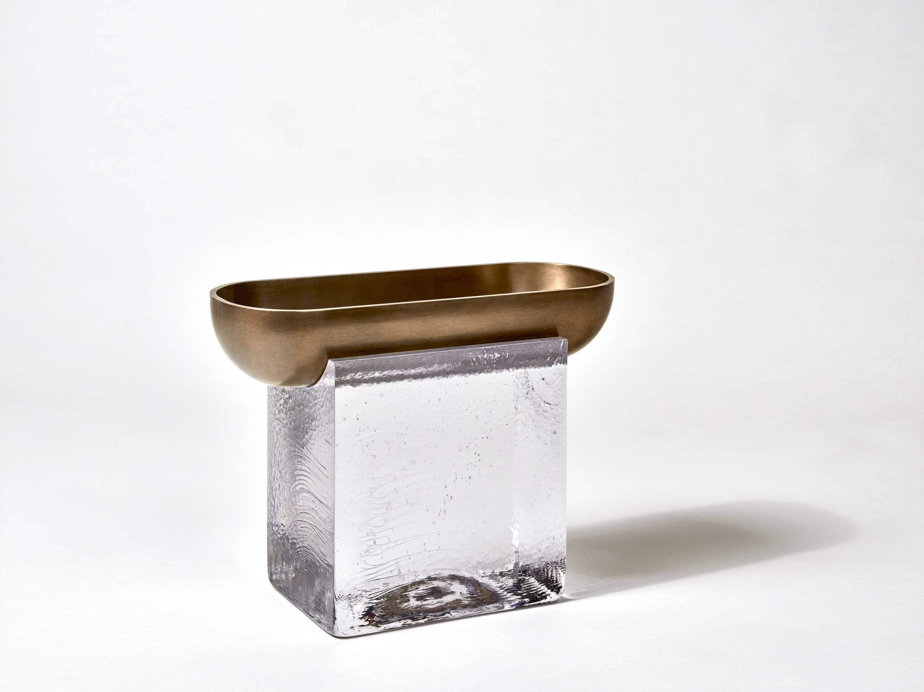 Block is a series of objects comprised of brass forms that plummet into cast crystal volumes. Molten Swedish Barium crystal is poured into textured graphite molds, giving the cooled blocks the appearance of ice. The crystal acts as a plinth, both