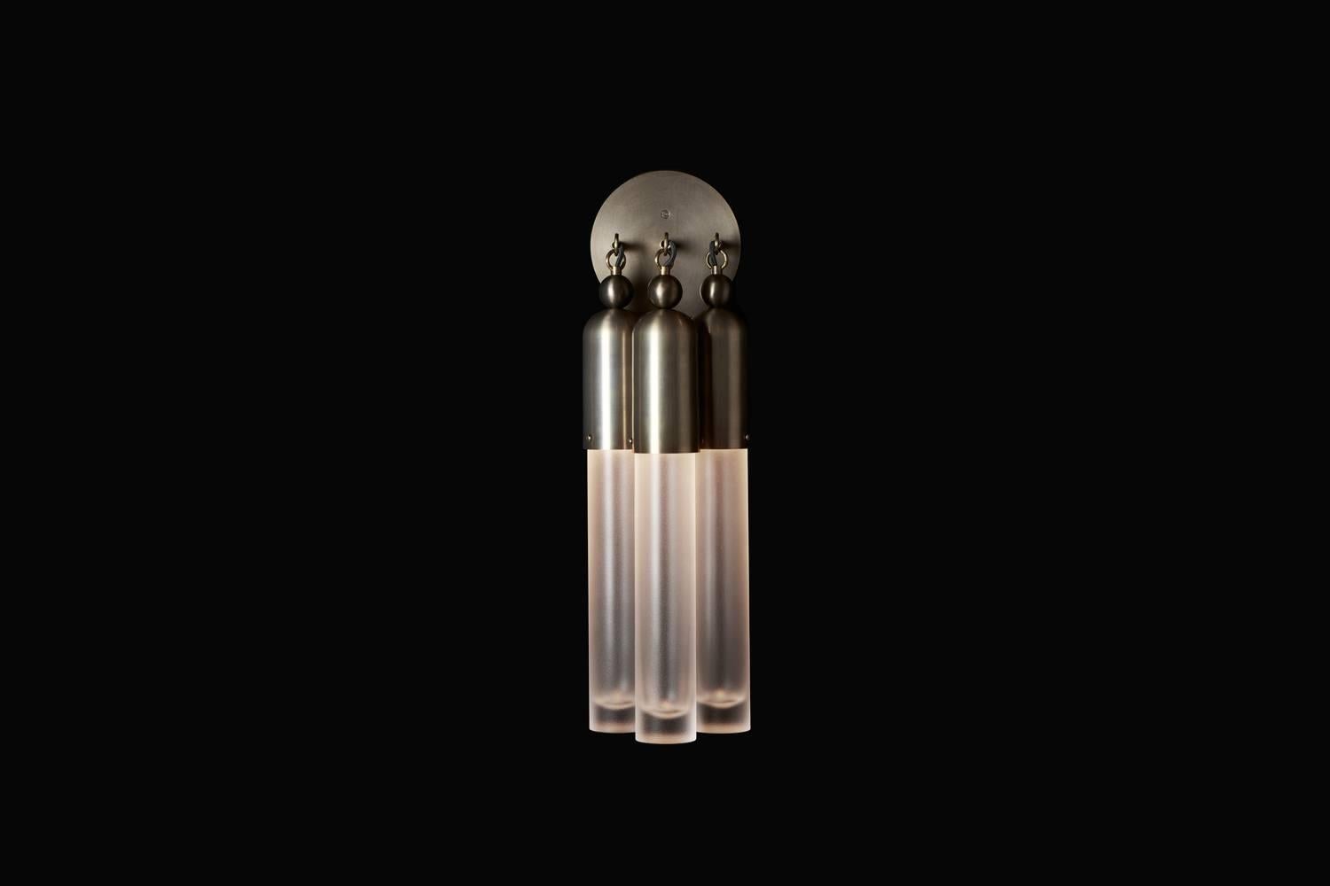The Tassel series condenses the warmth and decadence of a traditional chandelier to a concise, modern conclusion. Emanating from a brass dome, the light is amplified as it refracts through mold-blown glass cylinders.

The Tassel 3 sconce uses a