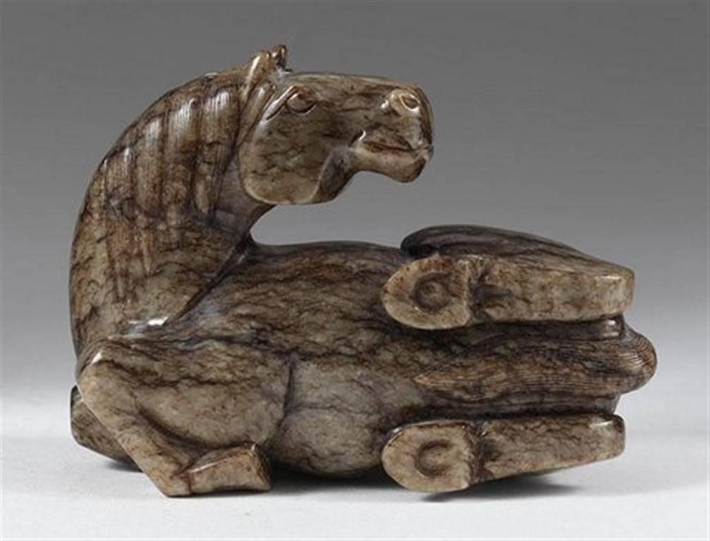 Recumbent horse carved of mottled black and white Nephrite Jade, Chinese, 20th century.

Carved retaining the natural form of the boulder, the horse lifting its legs as if playfully rolling.

Height 6 in.
Width 7 in.
Depth 3.5