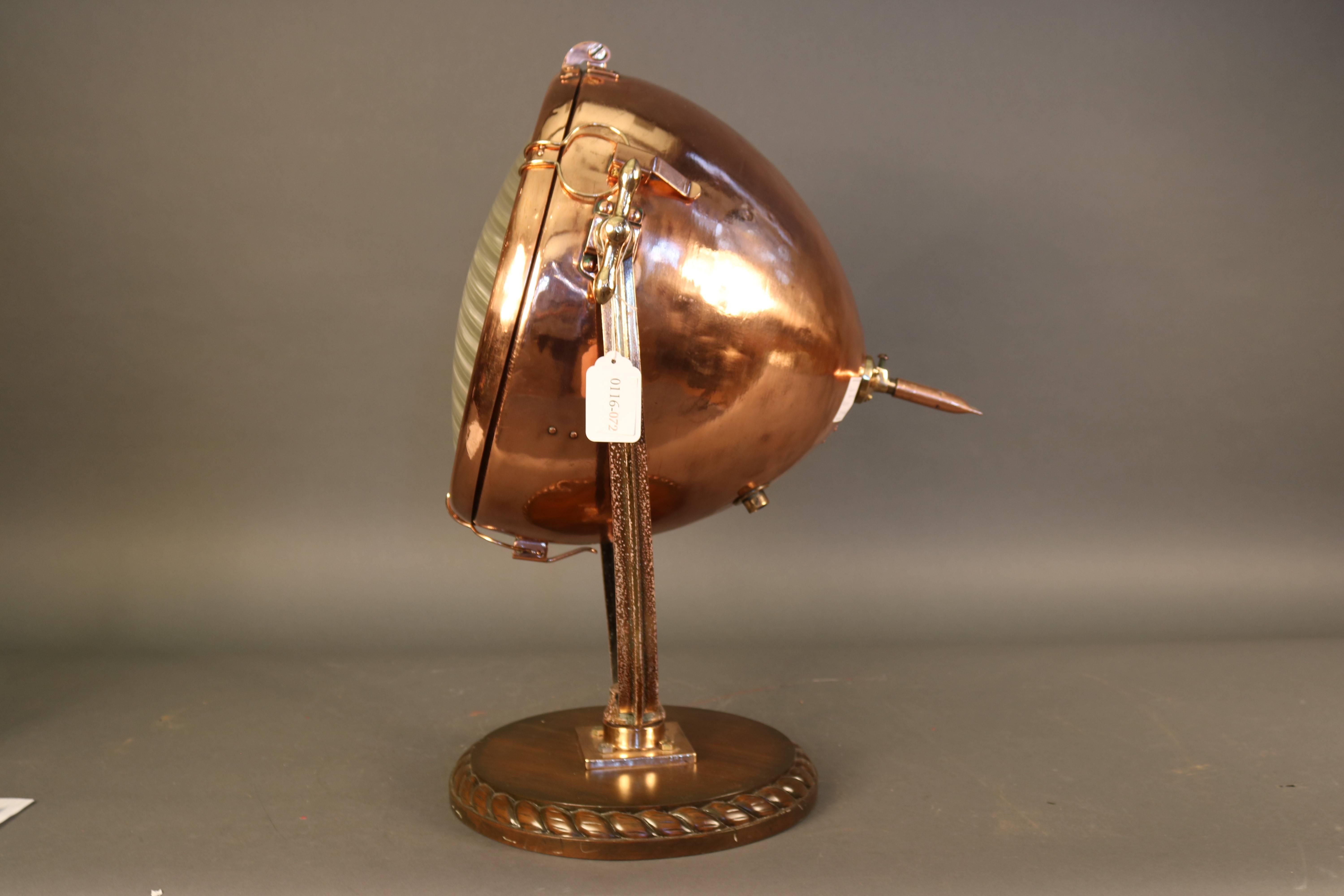 Copper yacht or ship floodlight with ribbed glass lens by General Electric. Mounted to a round mahogany base with rope carving.