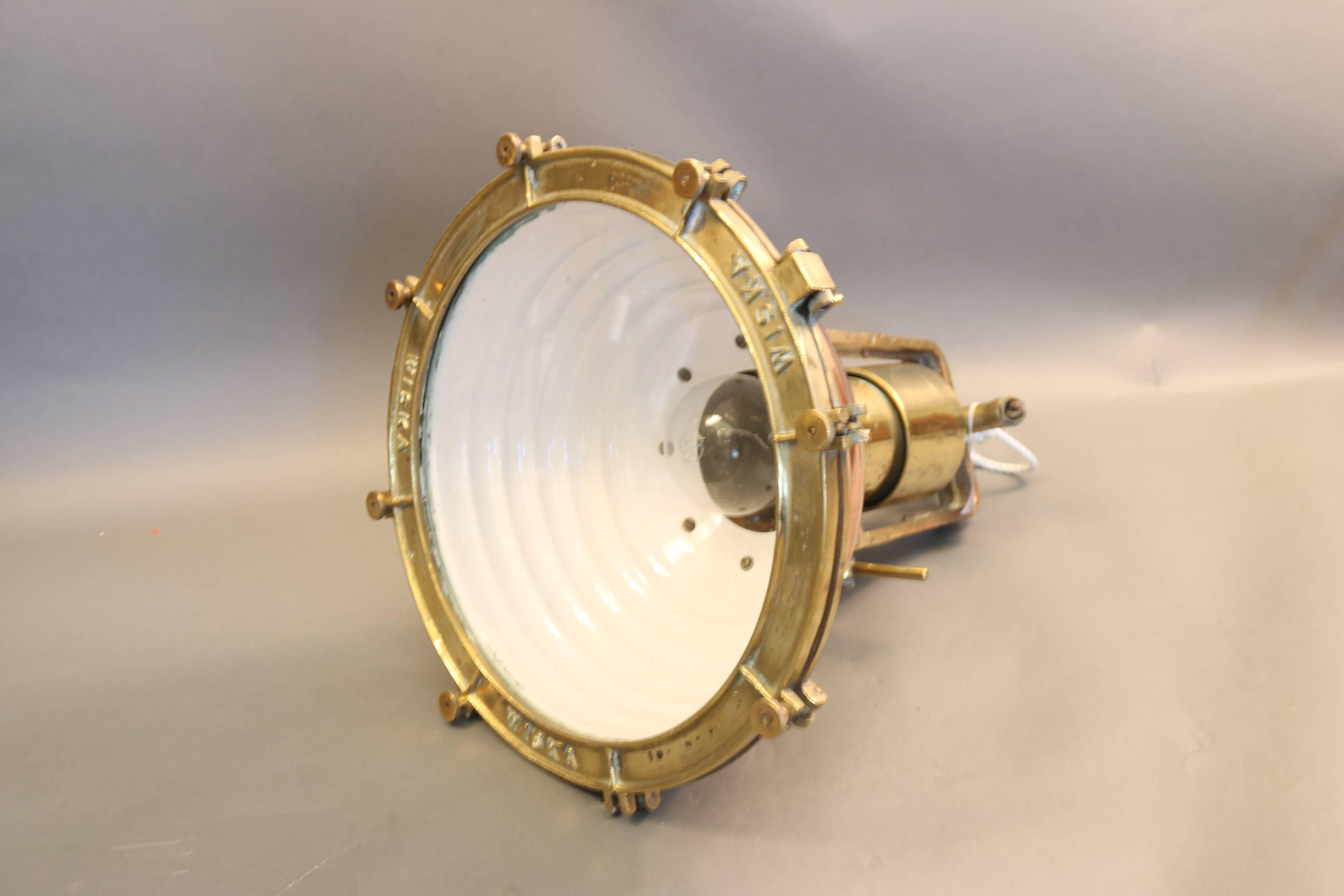 Ship's cargo light with ripped copper housing, brass bezel and glass lens. Fitted with a sturdy brass mounting yoke. 