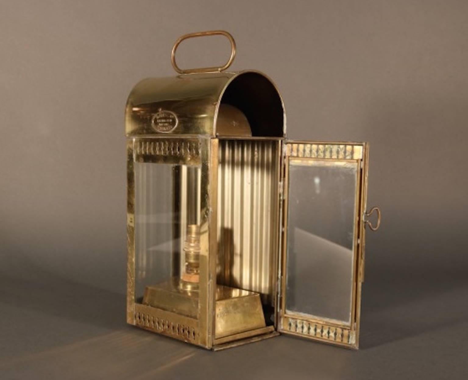 Brass ships cabin lantern by Davey and Co. of London with brass maker's badge, vented top, hinged door, glass panes, hoisting handle and etc. 
Dimensions: 15" L x 6" W x 4.5" H.
Weight: 4lbs.