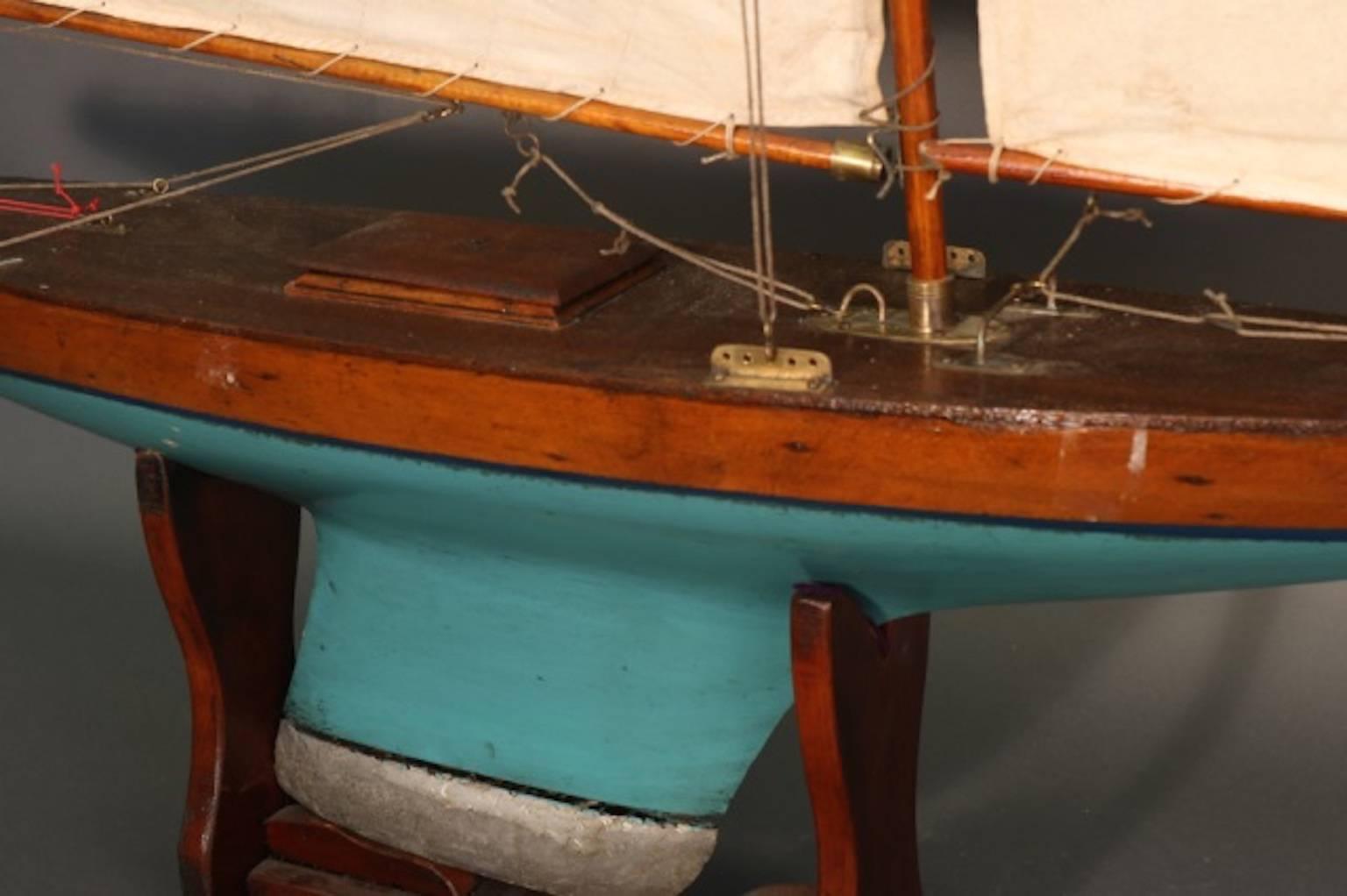 Vintage model of a two masted pond yacht, with lead keel. Hull is painted white over red. Rigged with linen sails. Dimensions: 48" L x 10" W x 40" H. Weight: 7.5lbs.