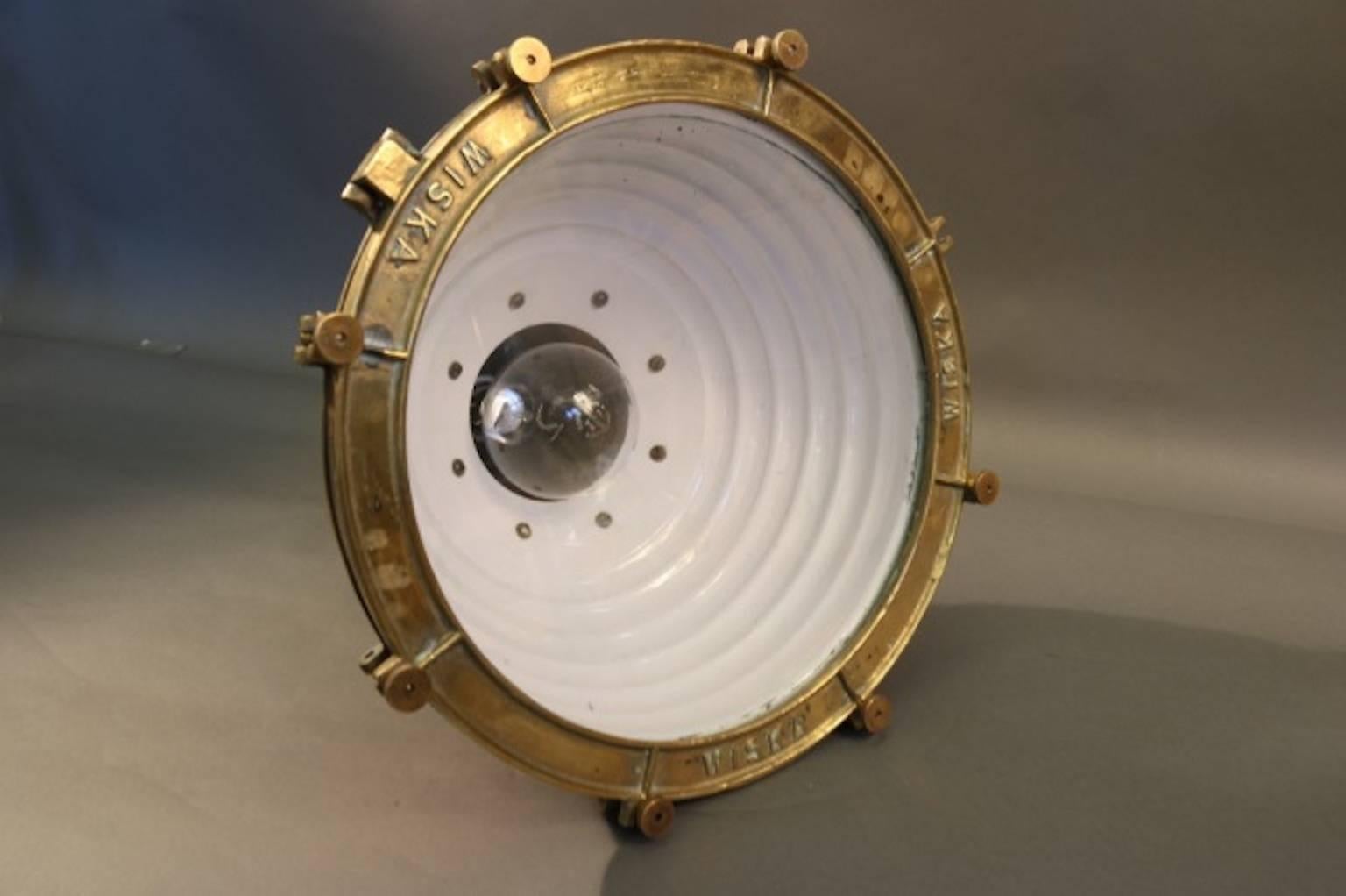 Spun copper ship's cargo light with brass bezel and glass lens. Highly polished and electrified fitted with a hinged mounting bracket.
Dimensions: 23" height x 18" bezel diameter.
Weight: 40lbs.