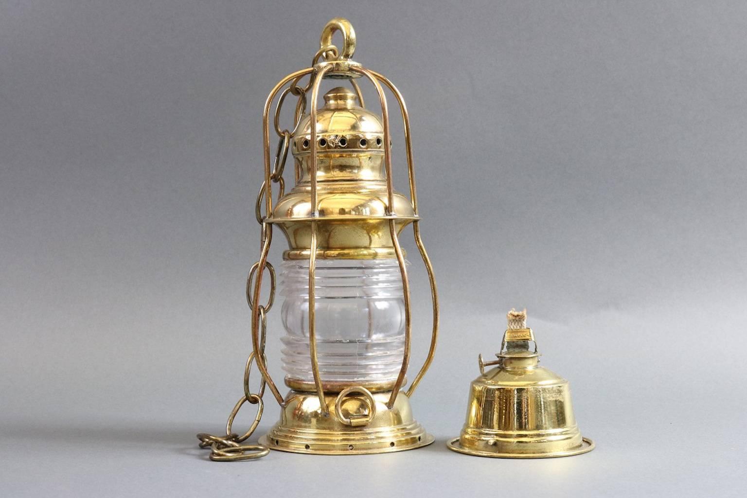 Solid brass ship's anchor lantern, small in size. Fresnel glass, with chip in rib. Dimensions: 5.5" diameter x 11" height.