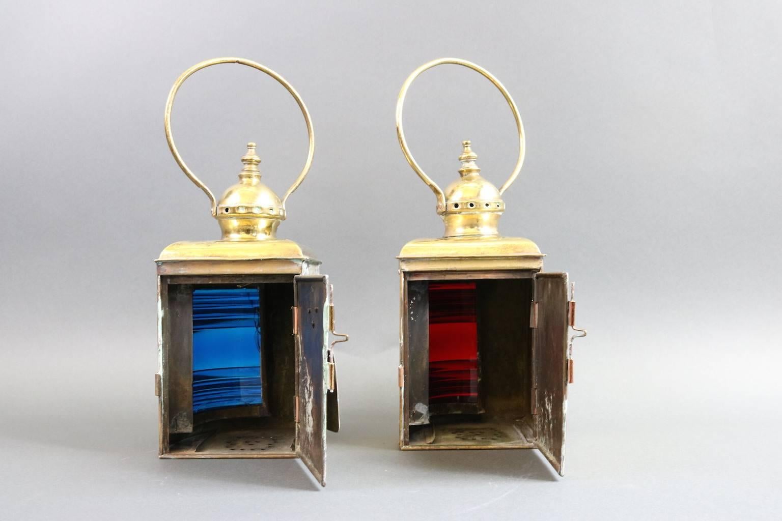 Pair of polished and lacquered port and starboard lanterns. Richly colored Fresnel lenses carry rings, hinged doors by Universal Metal Spinning & Stamping, New York. Sold as pair. Dimensions: 7" L x 5.5" W x 11" H (without handle).