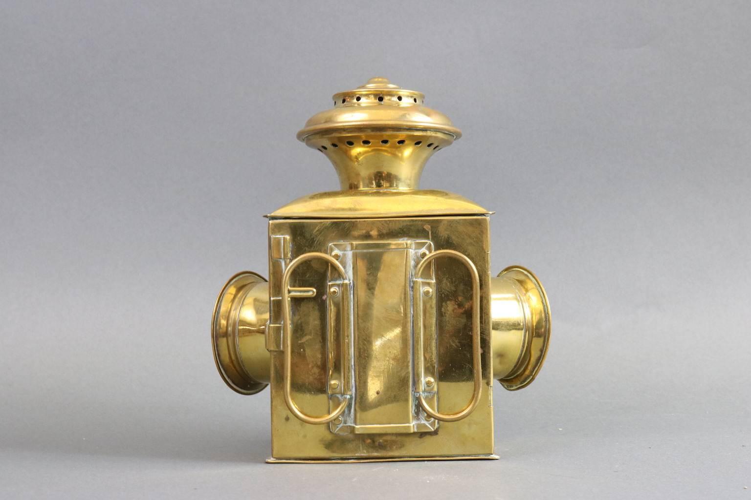 Brass bow lantern with red, clear and blue colored lenses. Mounted to a plaque, late 19th century. Dimensions: 8" L x 4.5" W x 8" H (without backing).