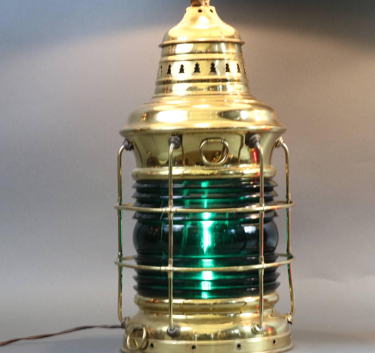 Outstanding pair of polished brass ship's lantern lamps by Perko, the Perkins Marine Lamp Company. Fitted with red and green lenses, thick Fresnel lenses. And protective brass cages. Dimensions: 10" diameter x 19" height.