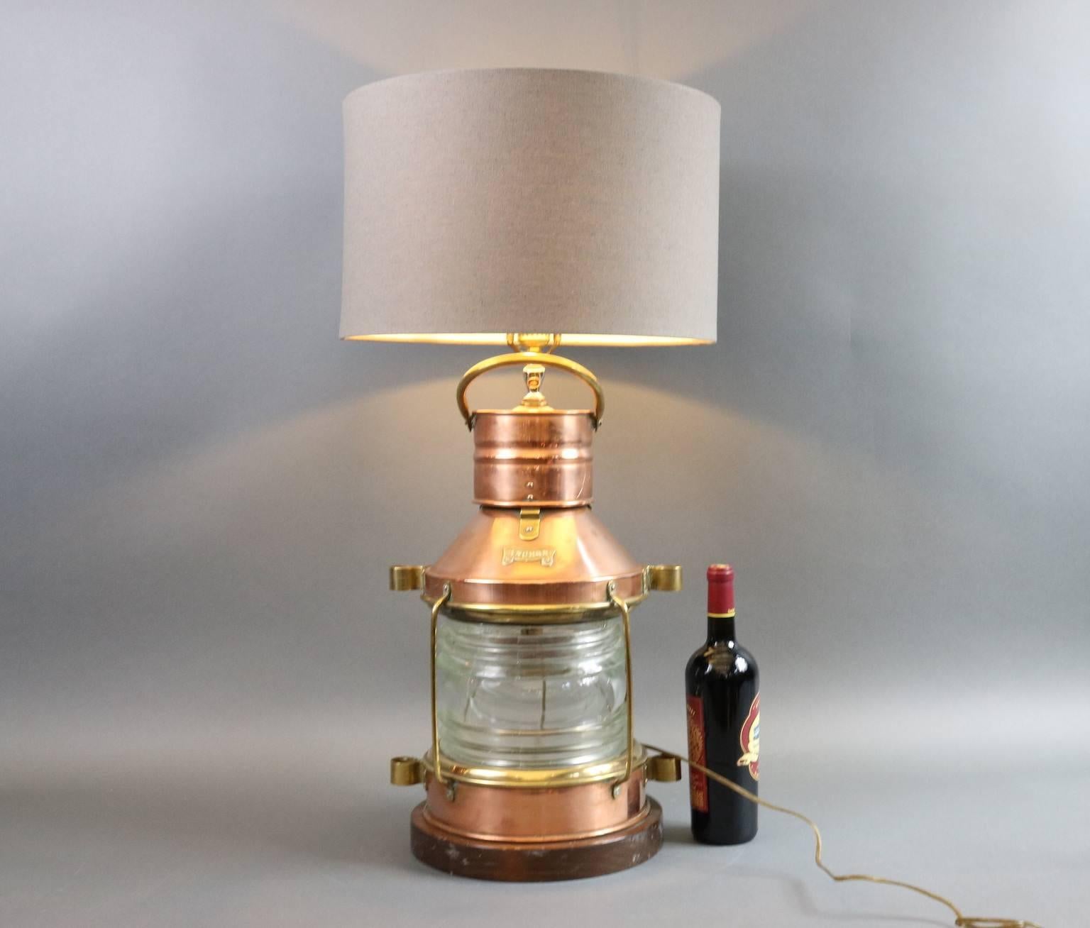 Ship's solid copper anchor lantern with Fresnel glass lens, brass bars, and etc. Lantern has been transformed into a lamp with thick wood base. Dimensions: 19" height (lantern only) x 12" diameter.