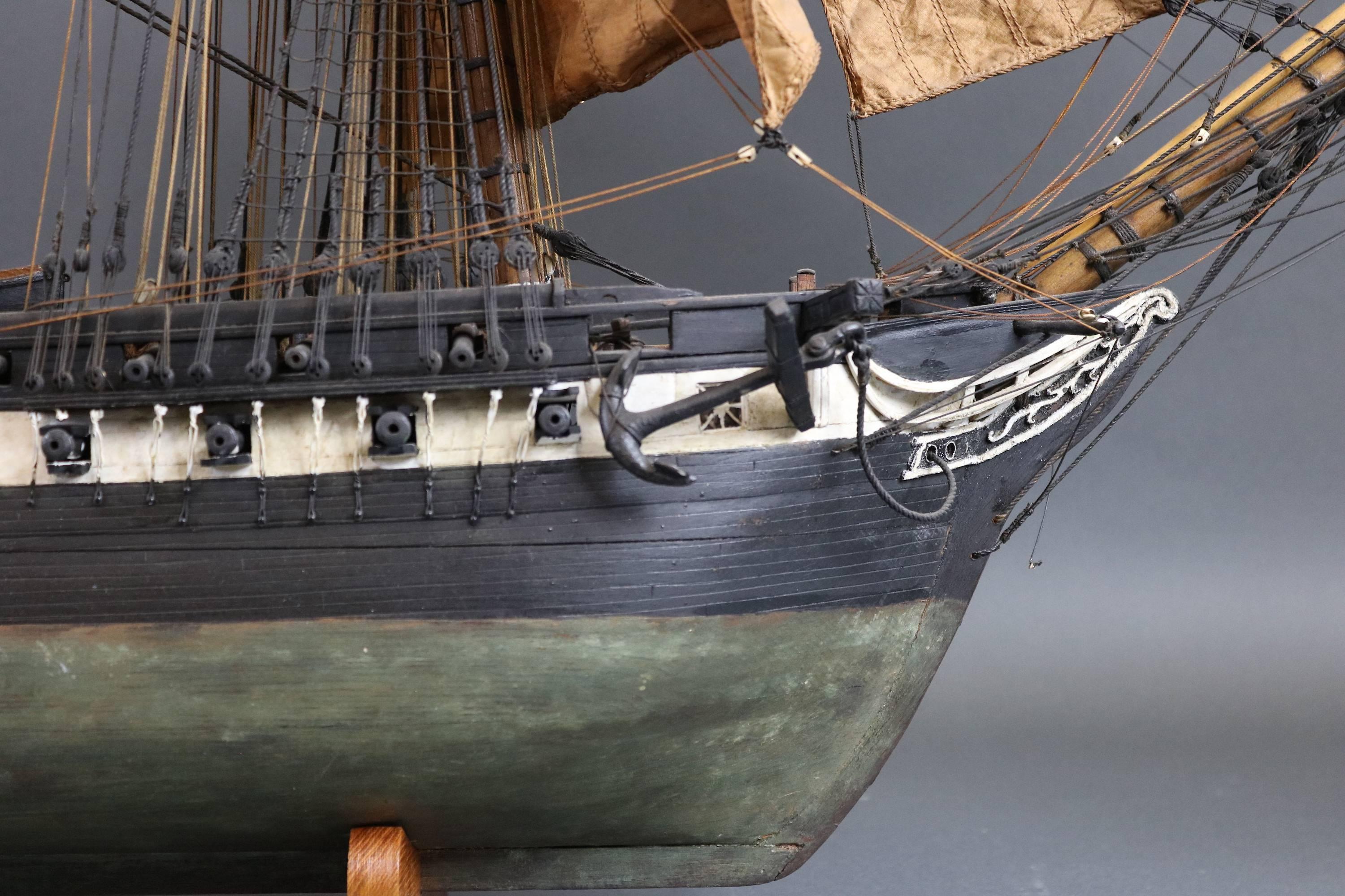 Exquisite antique model of the American frigate USS constitution. Fine 19th century model, rigged with a full suit of sails. Original flag that is showing its age. With scribed deck that carries wheeled carriages. The hollowed hull has built up