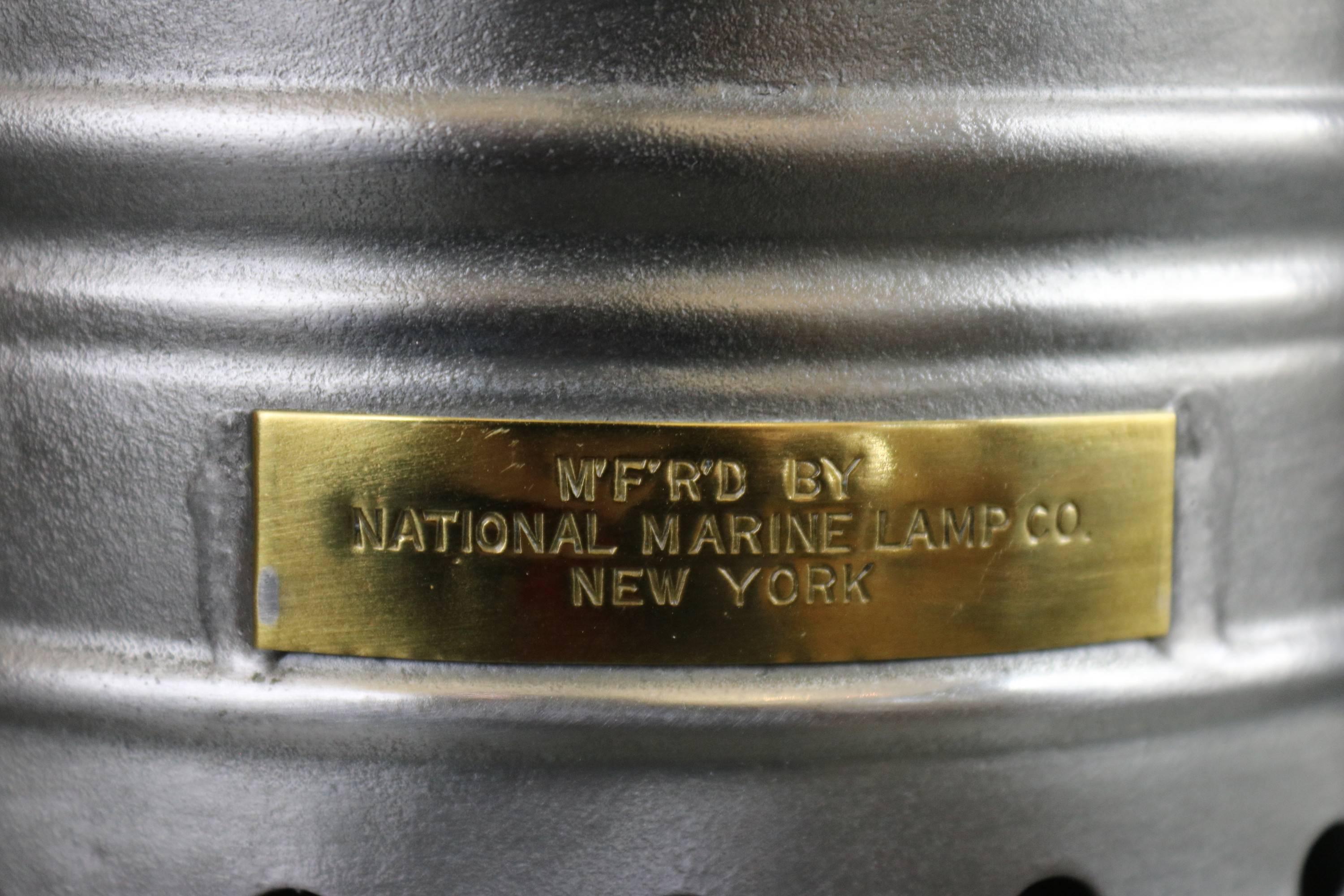 National Marine Lamp Company masthead lantern with fresnel lens, protective bars, brass badge reads "MFRD by National Marine Lamp Company, New York". Perspex fresnel lens. Measures: 12" long x 9" wide x 18" tall without