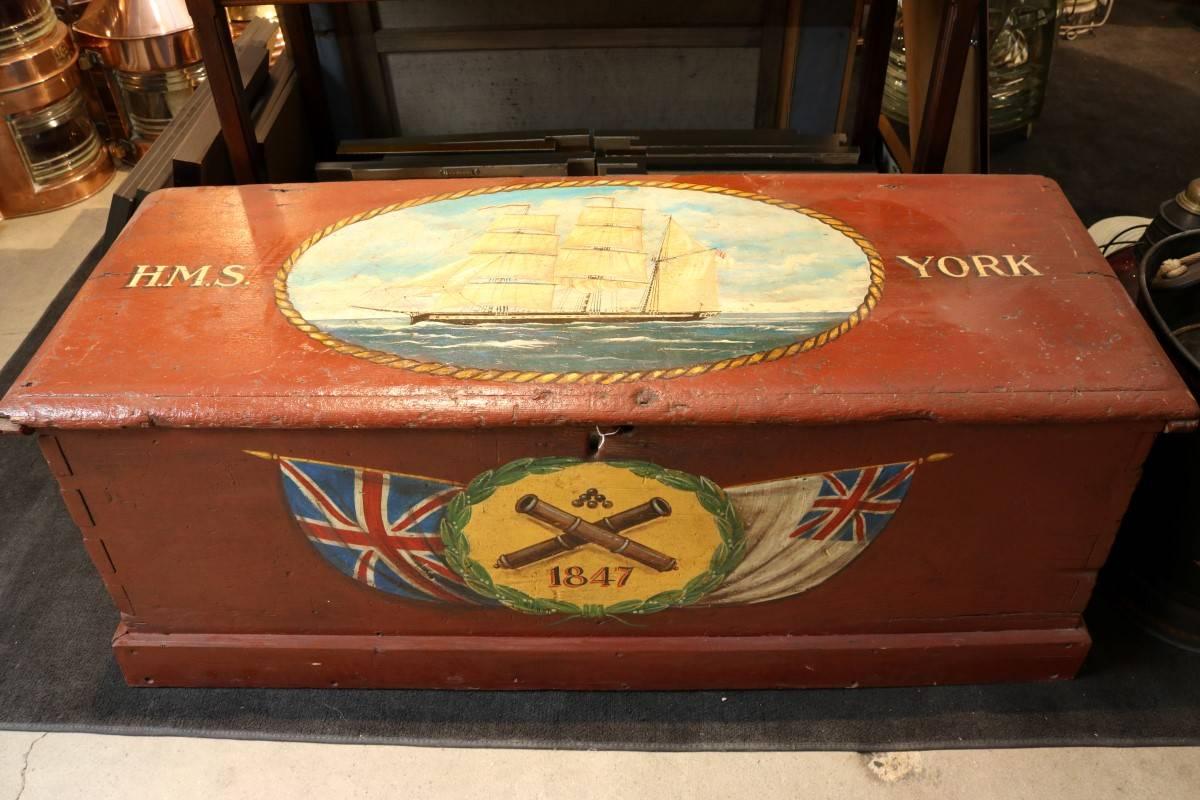 Antique sea chest with painted decoration of the HMS York from 1847. Hinged top, painted red. Dimensions: 51" L x 18" W x 17" H.