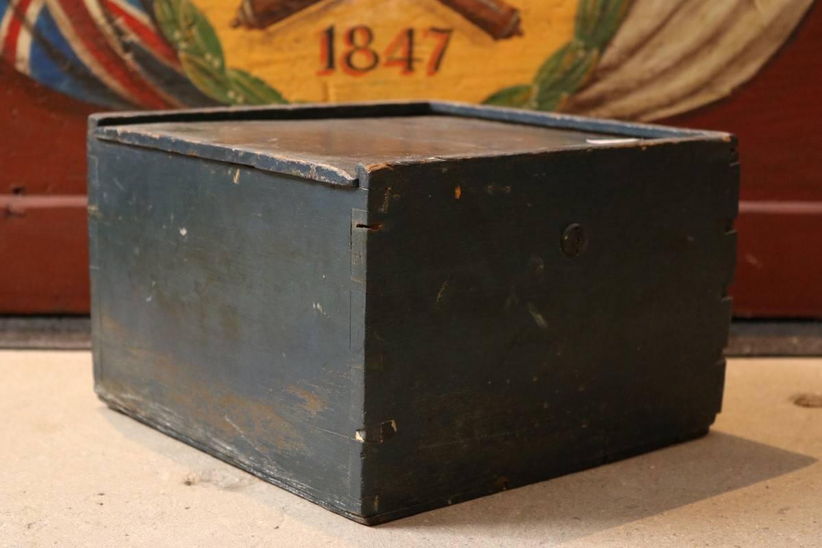 19th century compass by Robert Merrill, dry compass card mounted to timber box on a gimbal. Sliding lid top. Box is painted blue. Dimensions: 8