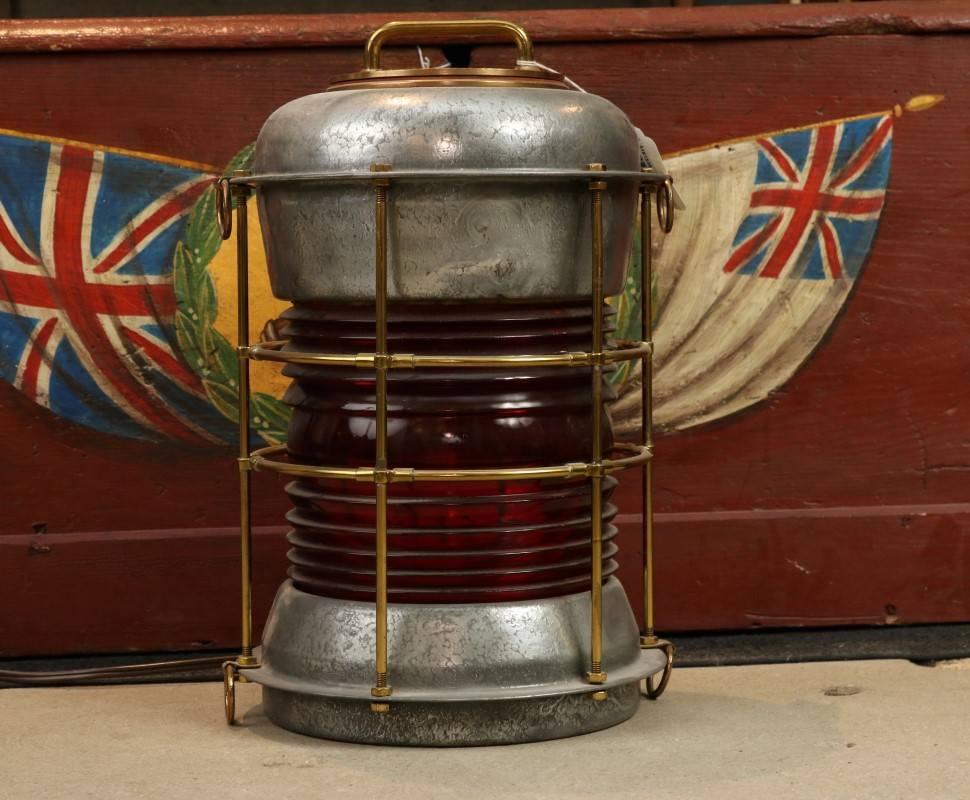 Durkee Marine ship's lantern with red Fresnel lens, 360 degree, galvanized steel with brass top, brass protective bars, manufacturer's stamp on top reads "Staten Island, NY". Electrified. Dimensions: 16" H x 11" diameter.