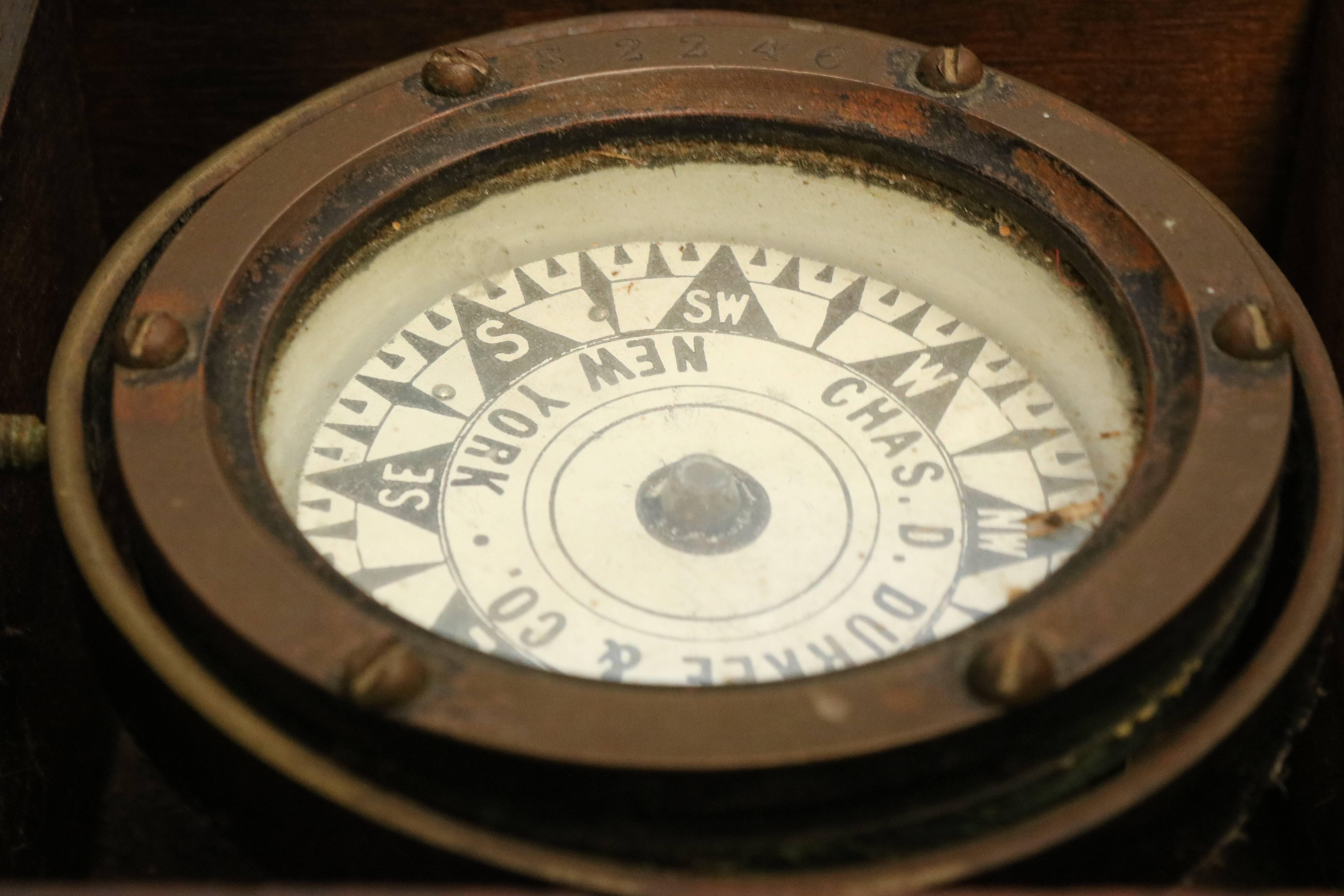 Early 1900s boxed compass by Durkee. Stamped Serial No. S2246, dry compass card reads abbreviated Charles D Durkee & Company, New York. Fitted by a gimbal to a varnished box with latch, no lid. Dimensions: 5 1/2" L x 3 1/2" H.