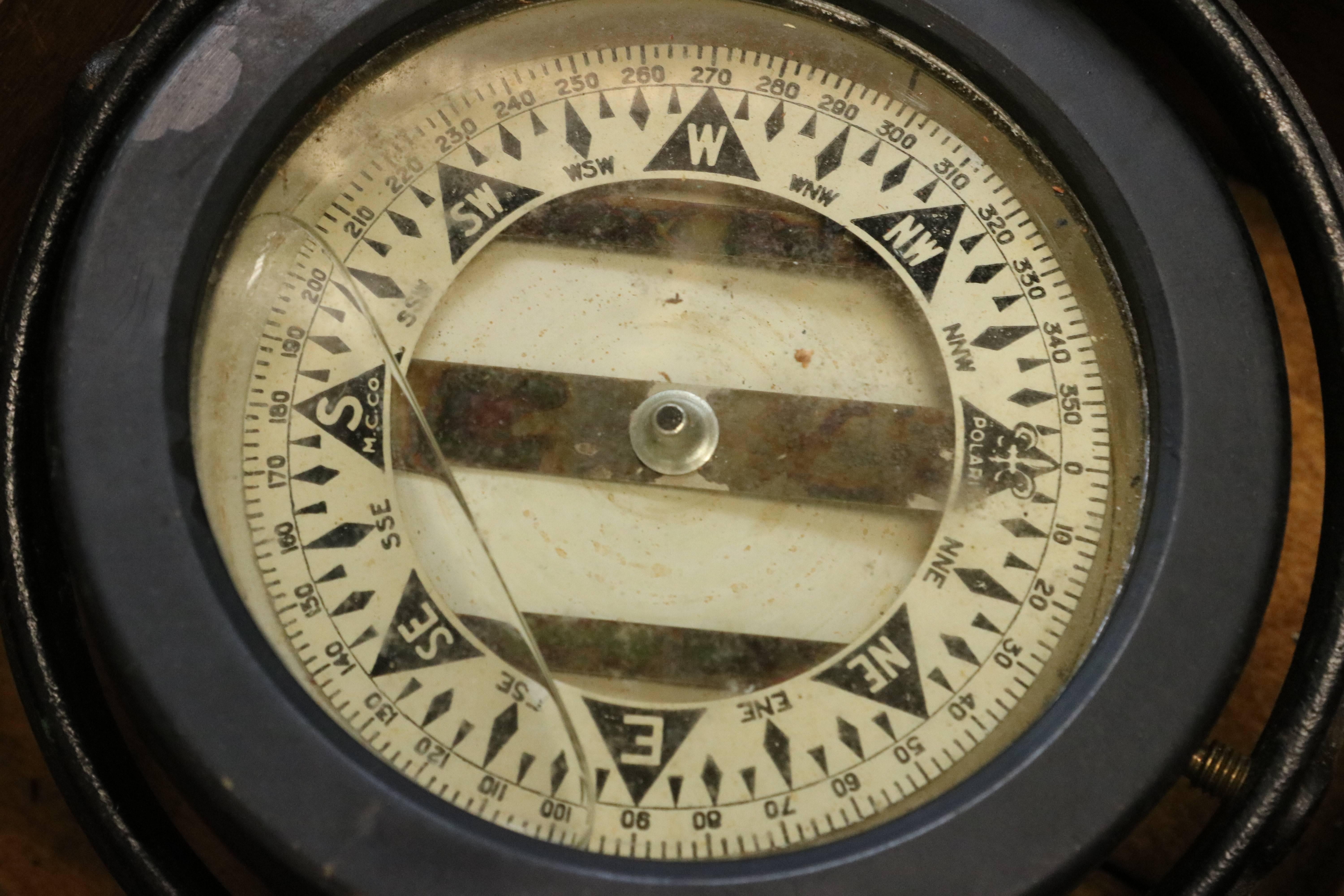Early polaris compass, liquid filled compass card fitted to a timber box with lid. Lid has crack. Prismatic viewing lens. Dimensions: 6" L x 6" W x 3 1/2" H.