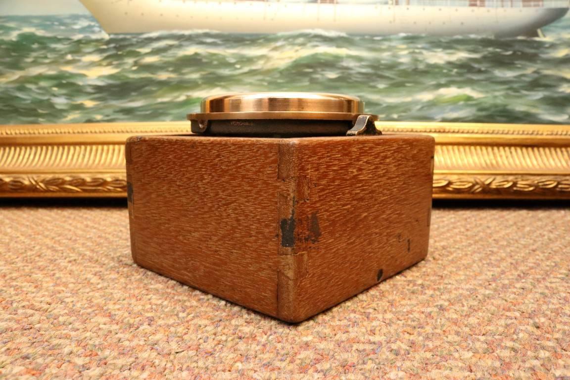 Boxed compass by Wilcox Crittenden. Alcohol filled compass card, alloy bezel, mounted to timber box with gimbal. Lid with latch. Dimensions: 5.5" L x 5.5" W x 4" H.
