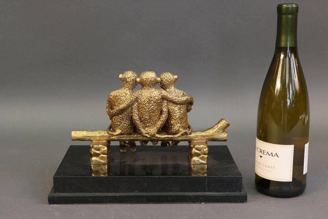 Desk accessory on a marble base of three cast brass monkeys on a log.

Overall dimensions: 12" x 7" x 9".