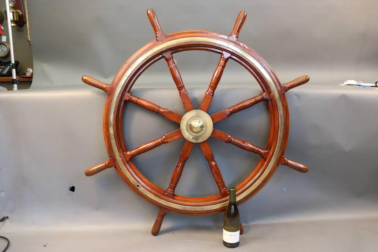 Eight-spoke ship's wheel with a brass hub and band inlay. Varnished finish.

Overall dimensions: 48" diameter.