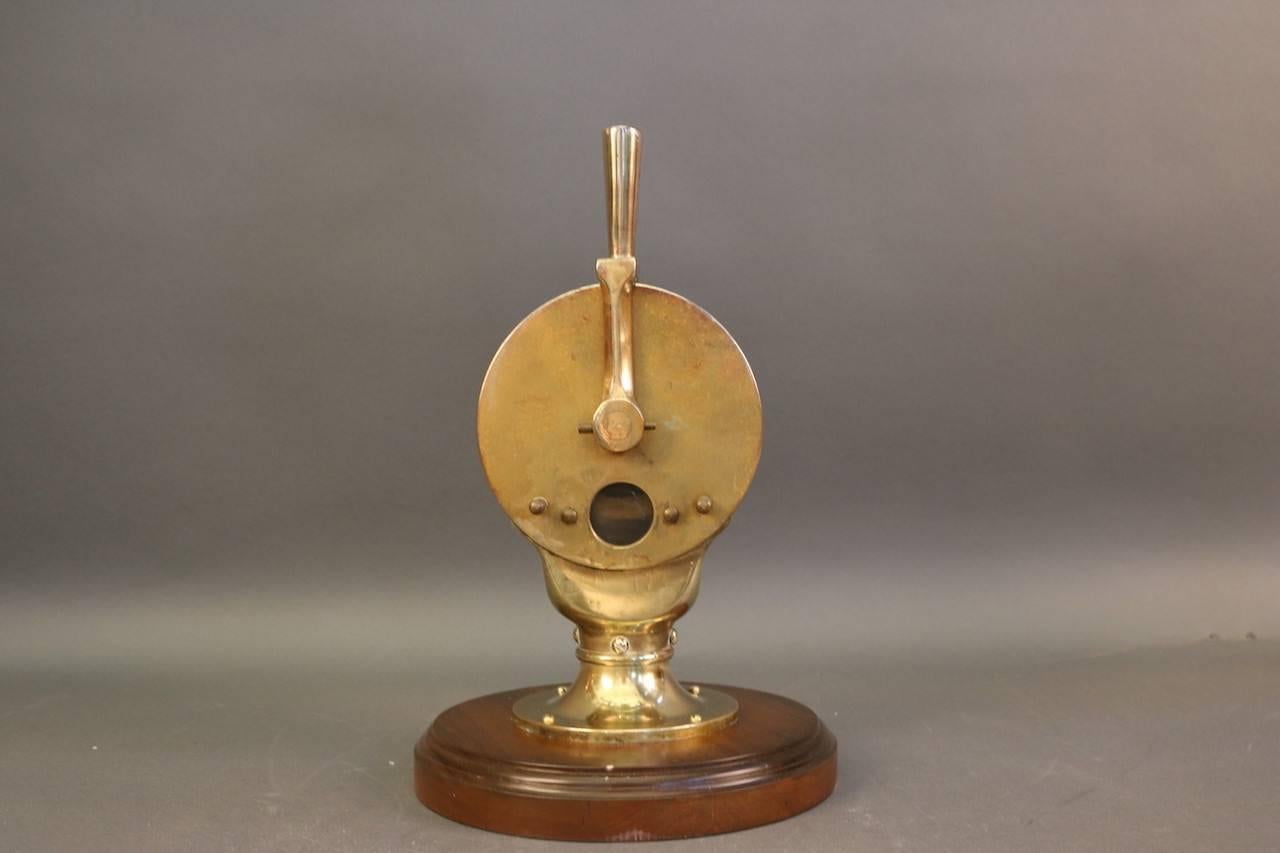 Engine order telegraph by Charles Cory and Sons, Inc. of New York. Single-sided face, brass case, handle, commands on face plate. Does not chime. Mounted to a wooden display base.

Overall dimensions: 18" H with handle x 7" face diameter