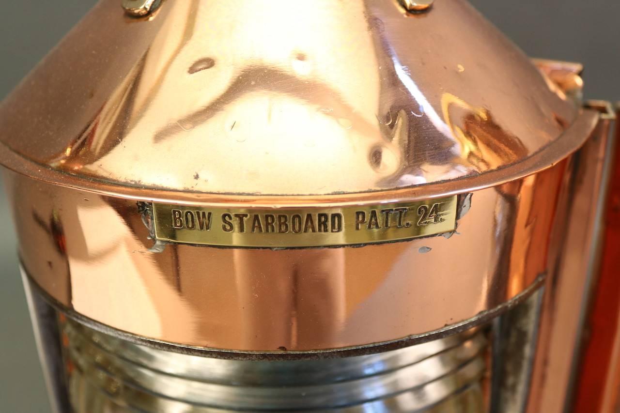Authentic pair of copper bow lights with Fresnel lenses, cornerback, rear door, carry handles, patent badges, hinged chimney tops and red and blue bulbs. Badges read: "Bow starboard patt 24" and "Bow port patt 23."

Overall