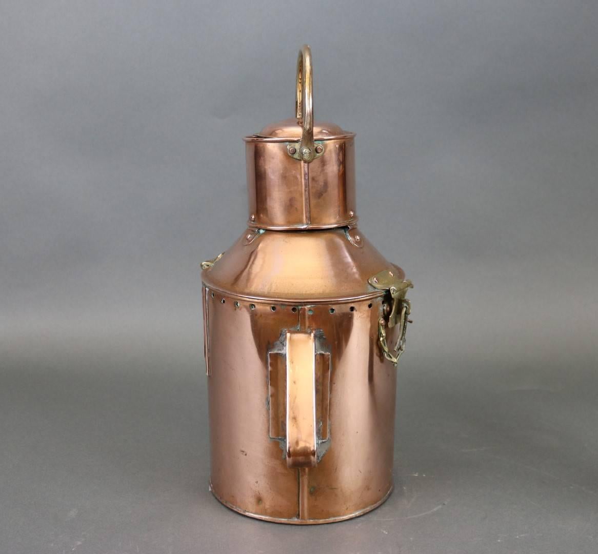 This is a hand held copper Signal lantern with Fresnel lens and a thumb operated shutter to send messages. Hinged top with brass clasp. Also contains original burner. Dimensions: 9" L x 10" W x 14" H (w/o handle).