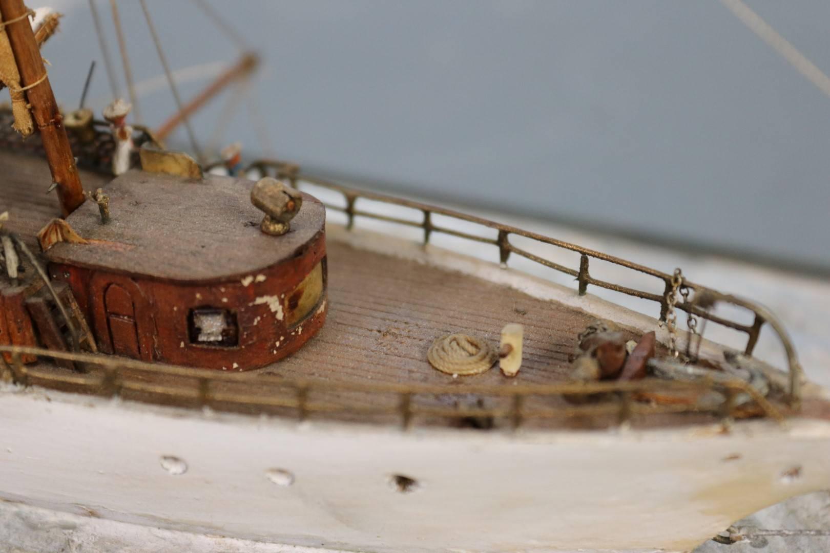 Fine miniature waterline model with cabin detail, two masts, launch and etc. Set into calm waters. Dimensions: 11.5" L x 3" W x 7" H.