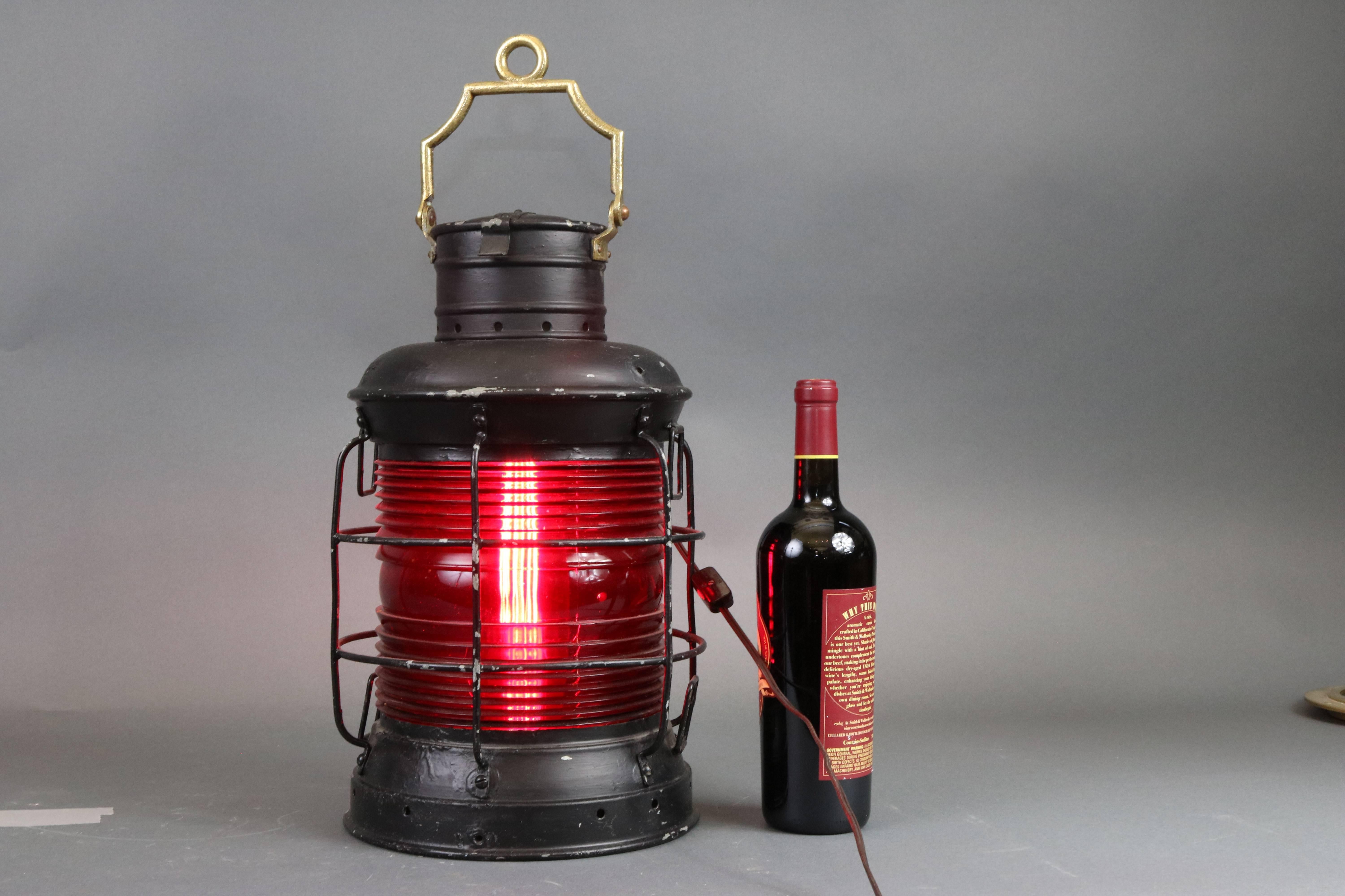 Sturdy old ship's lantern with red Fresnel lens, protective cage, tether rings, carry handle and etc. Dimensions: 10.5" diameter x 7" height (without handles).
