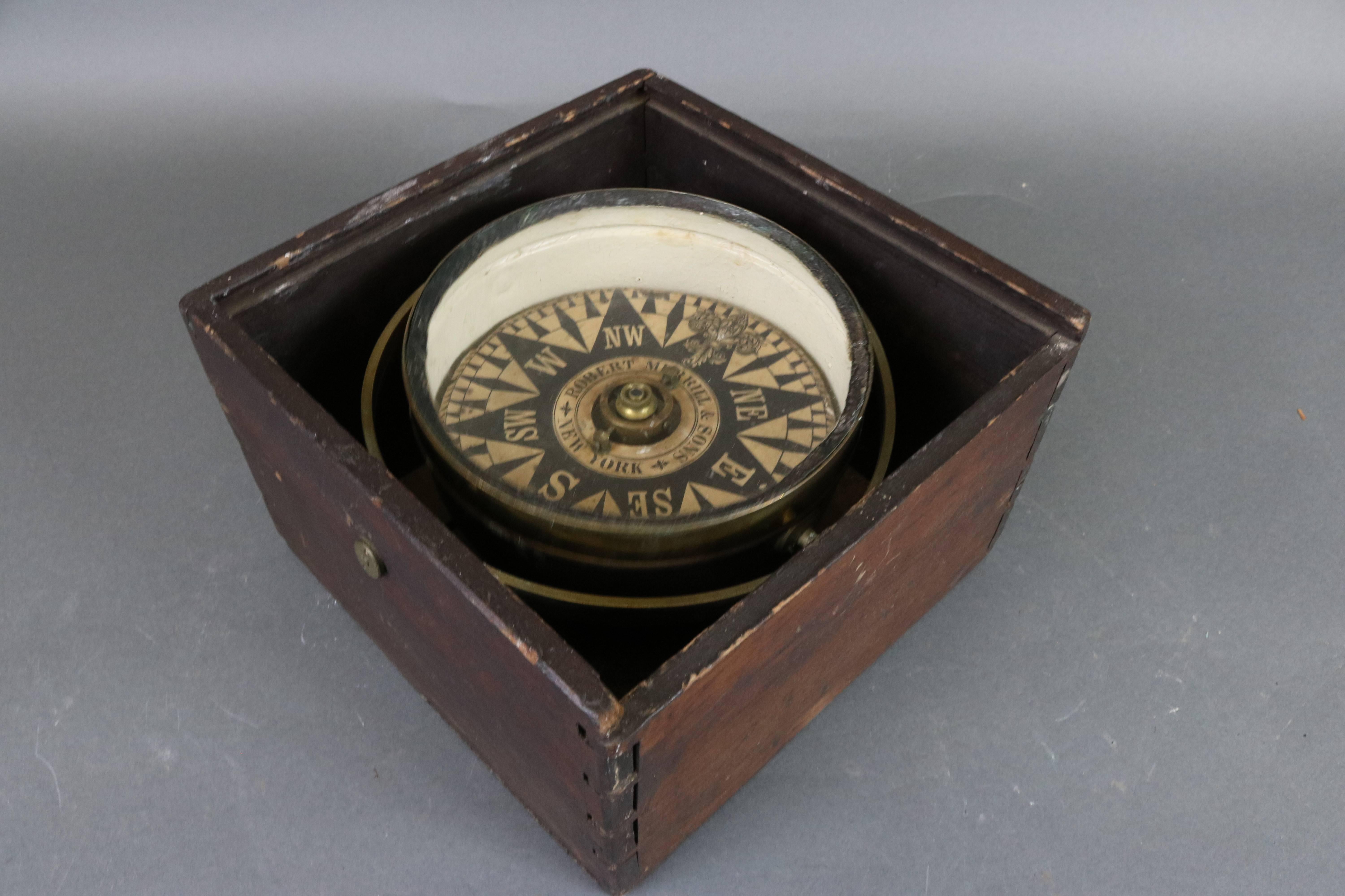 Mid-19th century ship's compass with dry card from Robert Merrrill and Sons, New York. Fitted to a timber box with sliding lid. Ornate axis. Dimensions: 10" L x 10" W x 6.5" H.