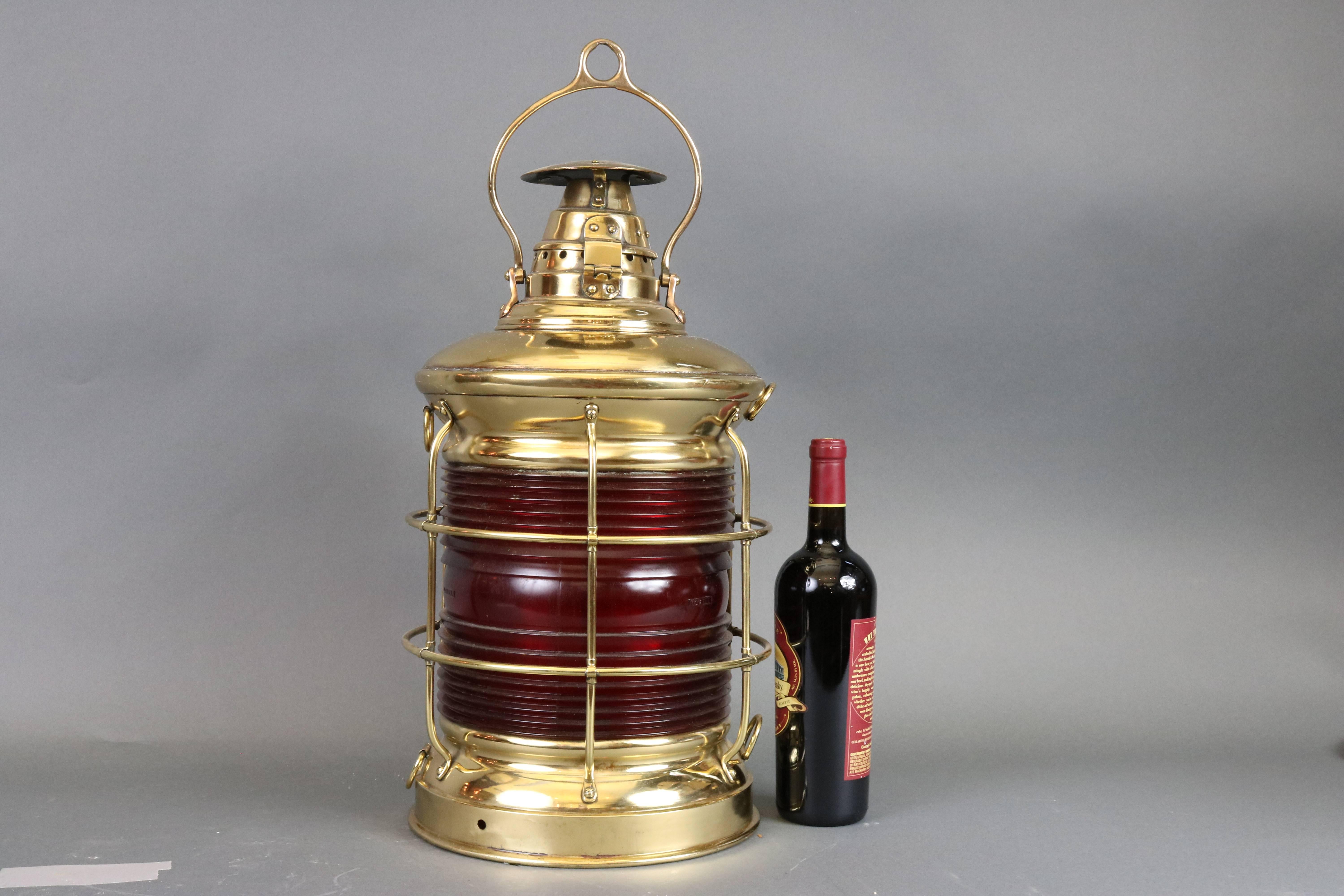 Quite large solid brass ship's lantern with warm patina. Red Fresnel lens, protective cage, tether rings. By Lovell. Very large monumental ship's light of museum quality. Dimensions: 11.5" diameter x 21" height (without handle).