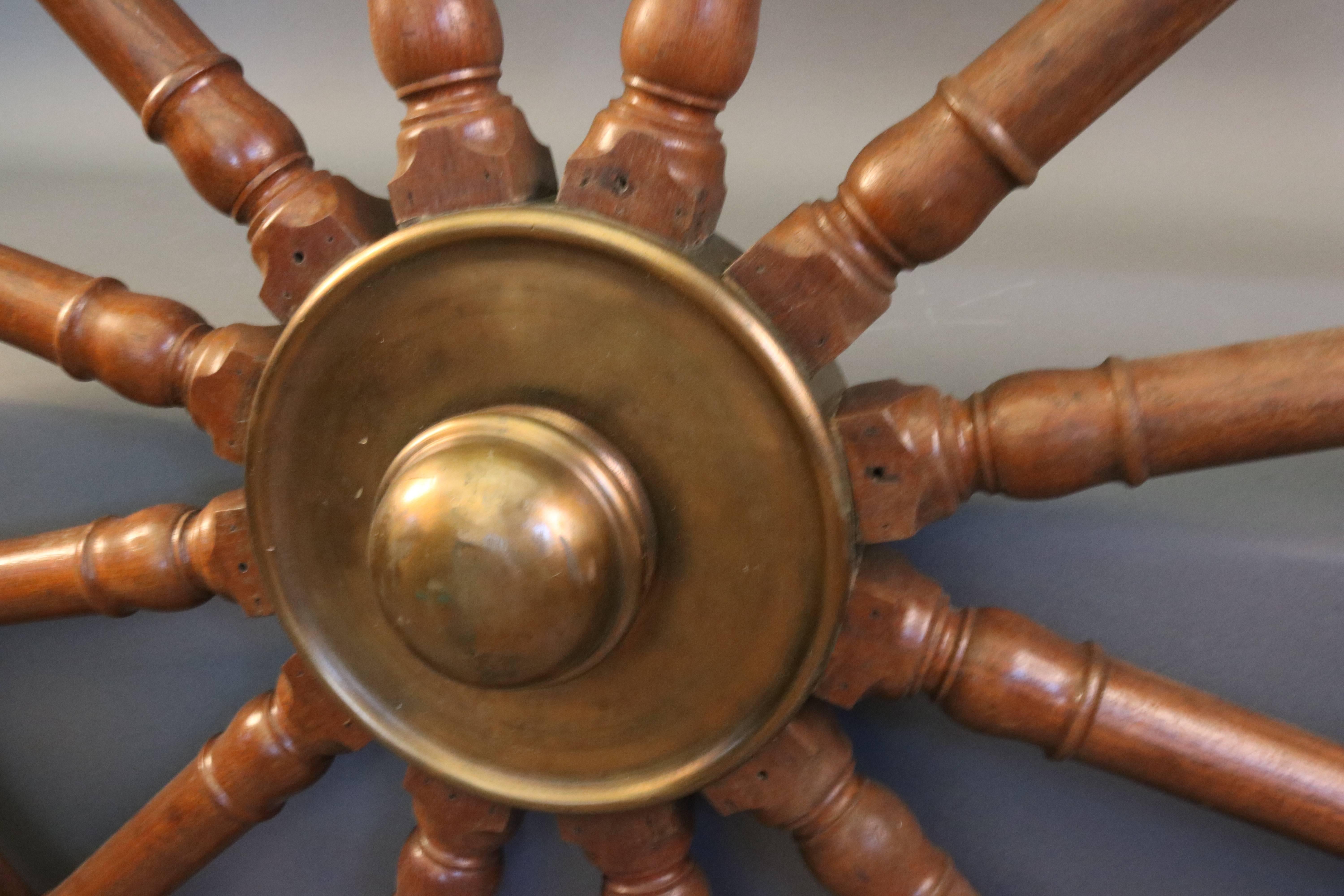 Massive five-foot ship's wheel with 12 turned spokes. Heavy brass hub with cap. Outer ring of wheel has a heavy brass ring. Overall dimensions: 60