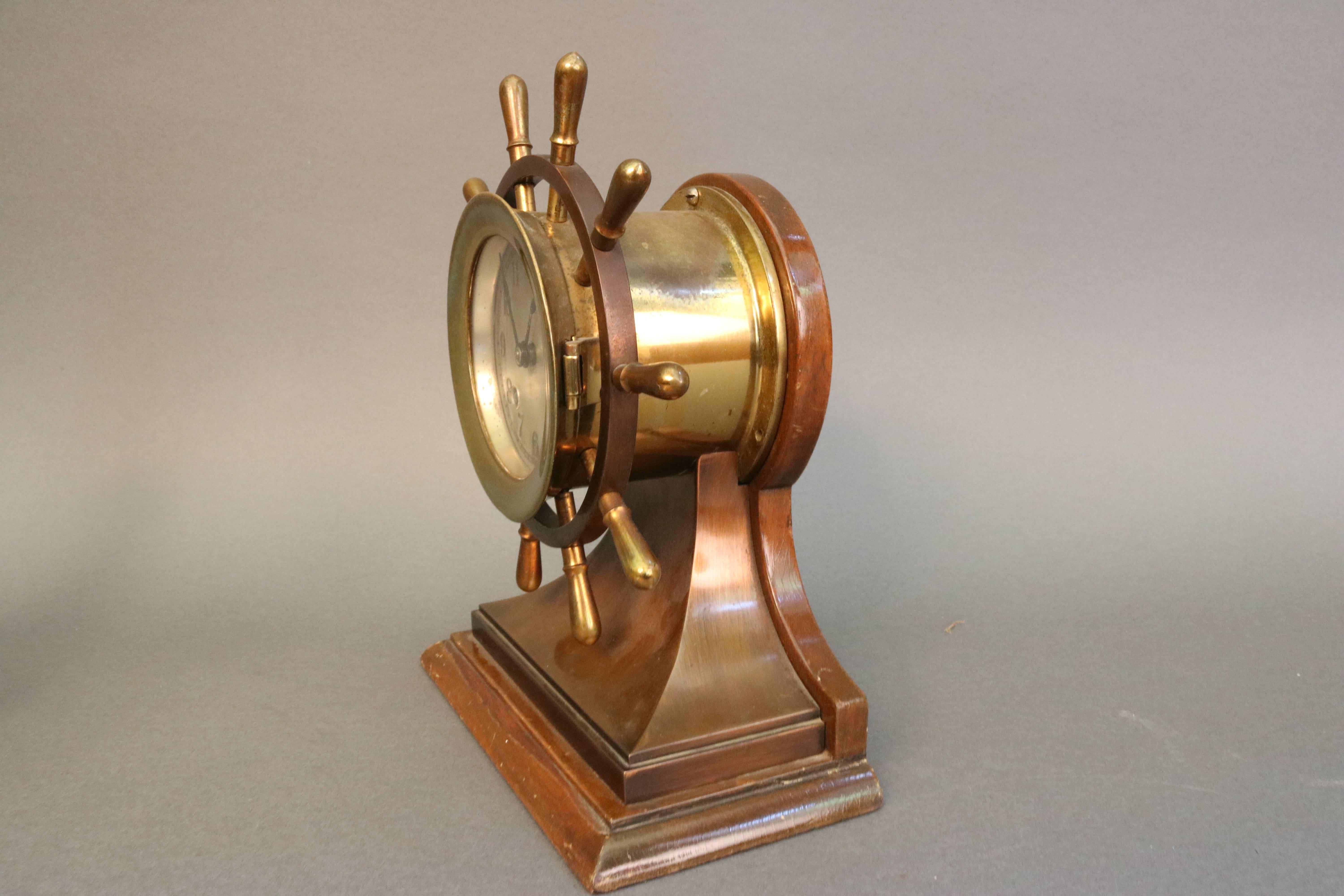 An American 20th century 3-1/2 inch ship's wheel clock unsigned and in the form of a Chelsea "Mariner." The clock features a slivered face, blackened Arabic numerals, simple hands, double barrel key winds for the movement and the strike,