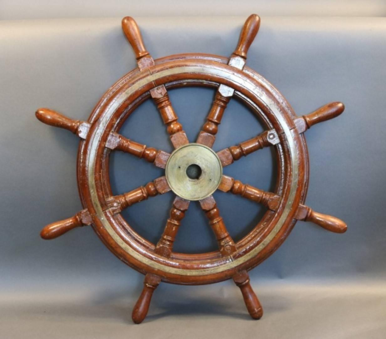 Brass and mahogany ship's wheel with eight turned spokes. The wheels outer rim is inlaid with brass trim. Heavy brass hub has a full cap.

Overall dimensions: 32" diameter.
  