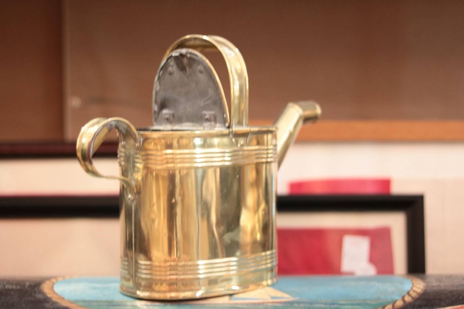 Early brass watering can with handles, spout and flip-top. 

Dimensions: 11