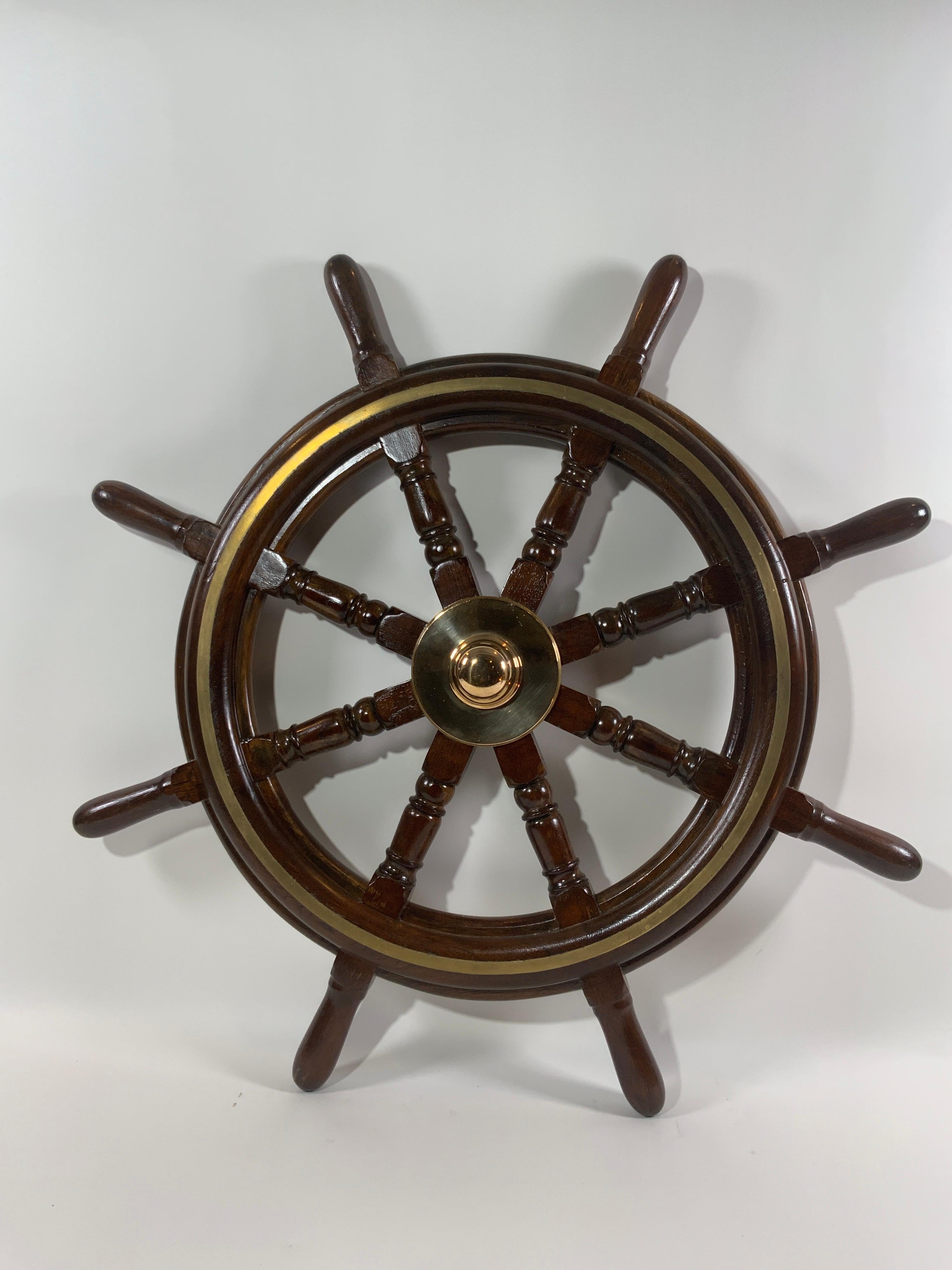 Eight-spoke ship's wheel with turned spokes, a brass hub and band inlay.

Overall dimensions: 38