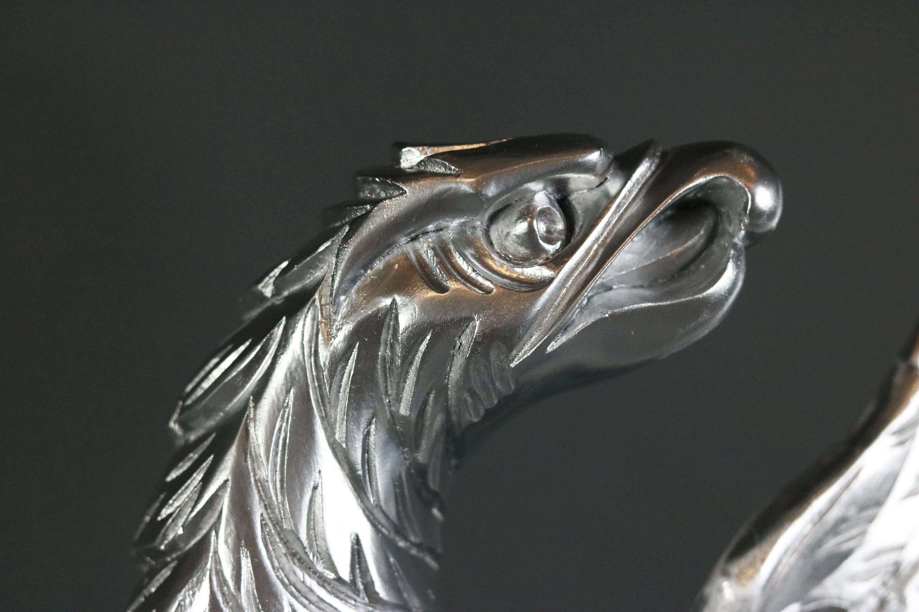 Carved wooden eagle painted silver. Eagle is very detailed and clutching the great seal in the likeness of the US Coat of Arms.

Rear hanging wire.

Measures: 19