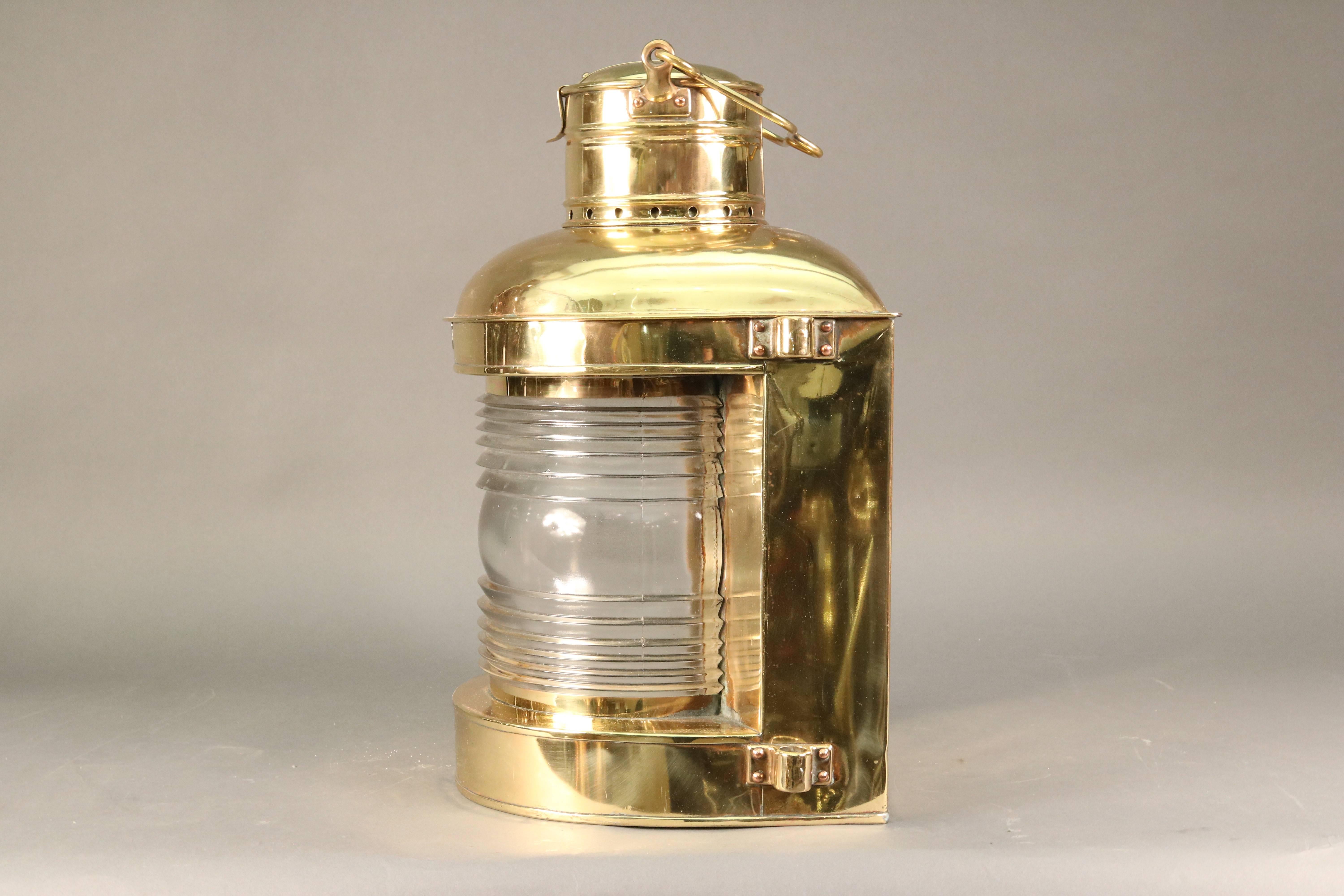 Brass masthead light by Perko with fresnel lens, carry handle and manufacturer's badge. 