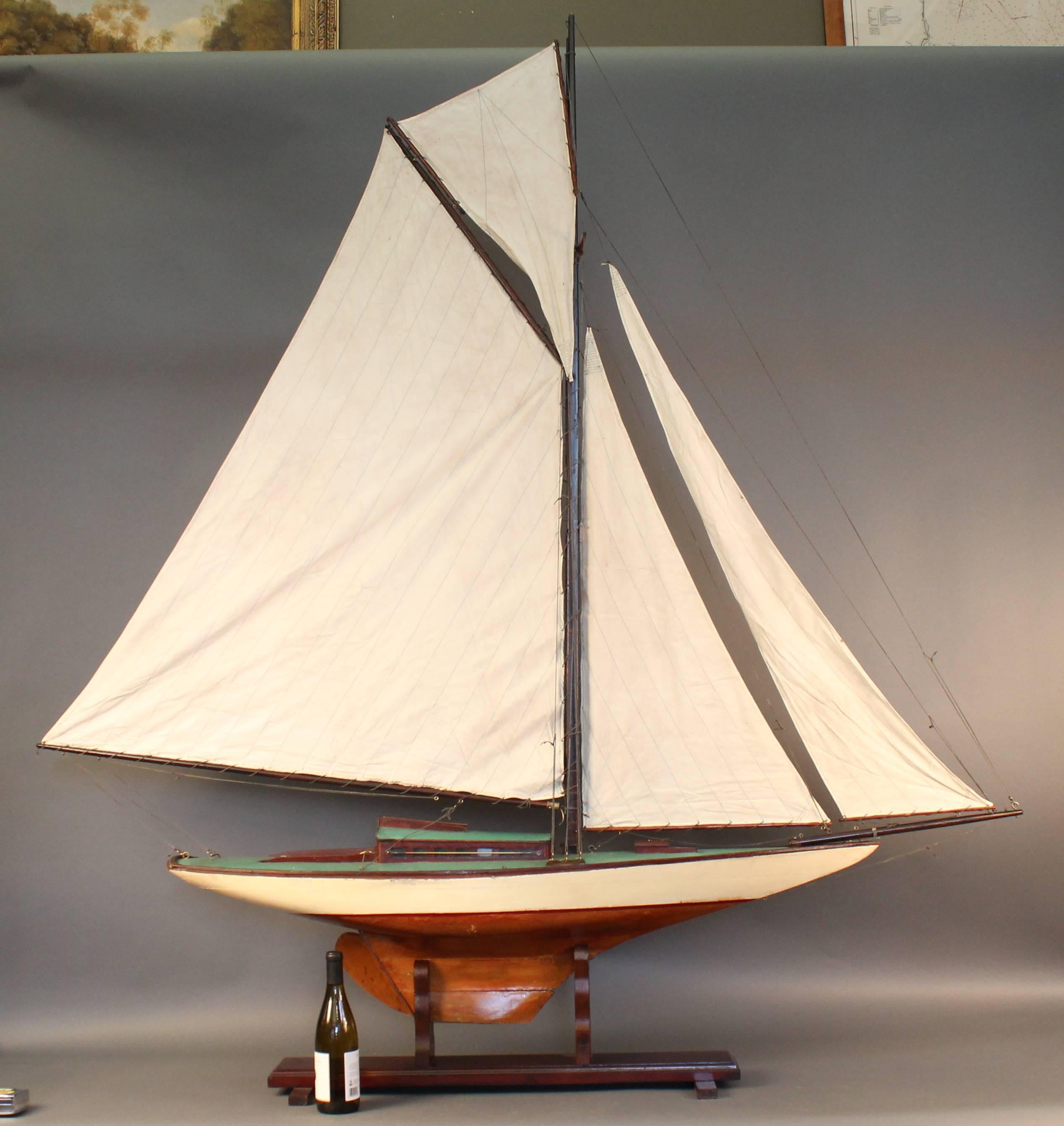 Wooden pond yacht with natural finish and painted white above the waterline. Linen sails, blue deck.

70" long x 11 1/2" wide x 78" high