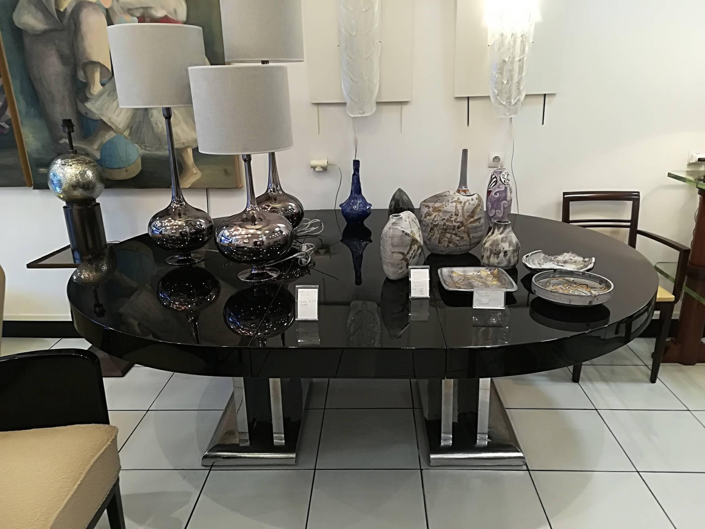 Spectacular dining room table. Original nickel-plated metal base. Black wooden lacquered top.
The top opens and comes with two extensions of 50 cm each one,
circa 1935.