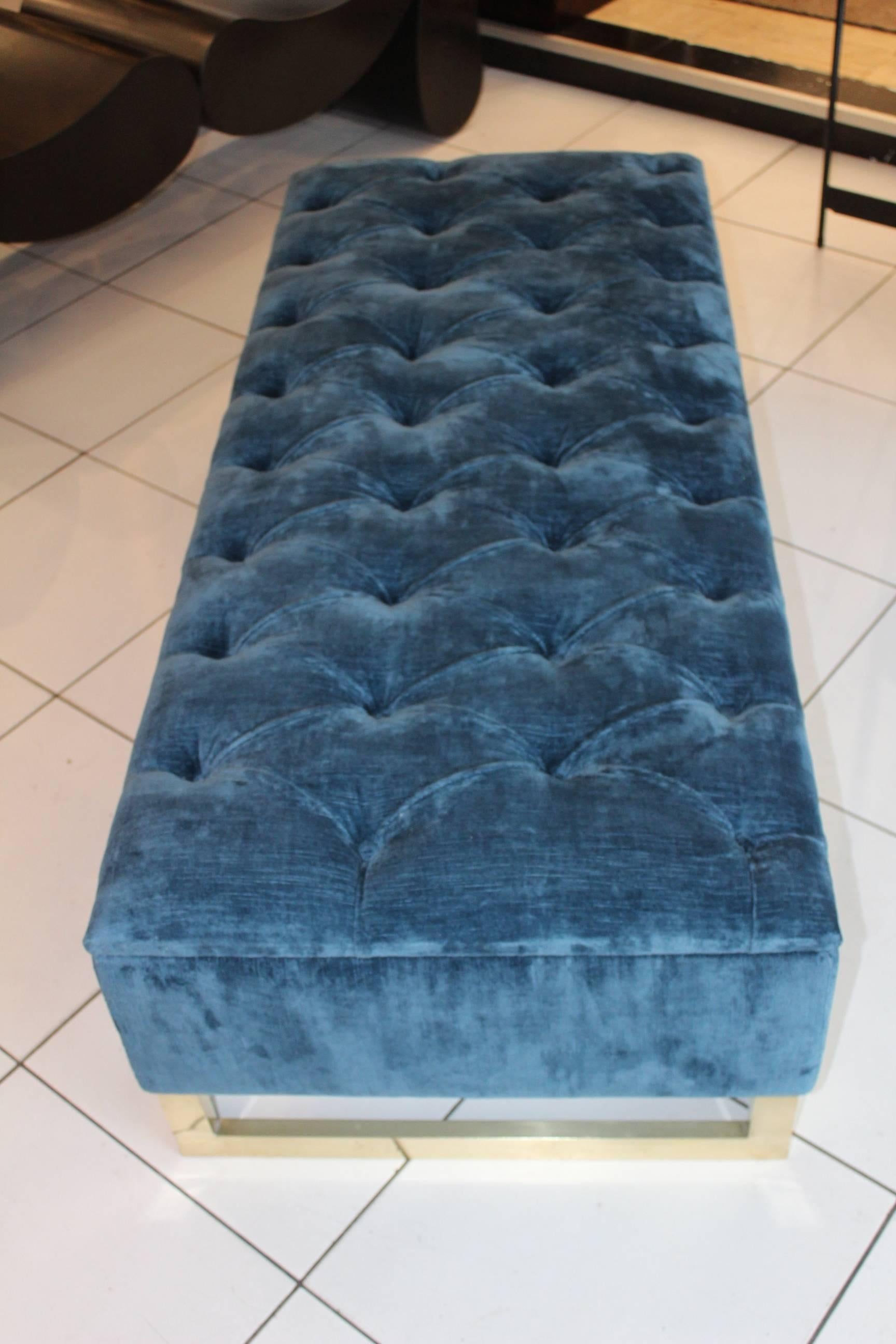 Blue velvet padded bench, brass feet, in excellent condition.